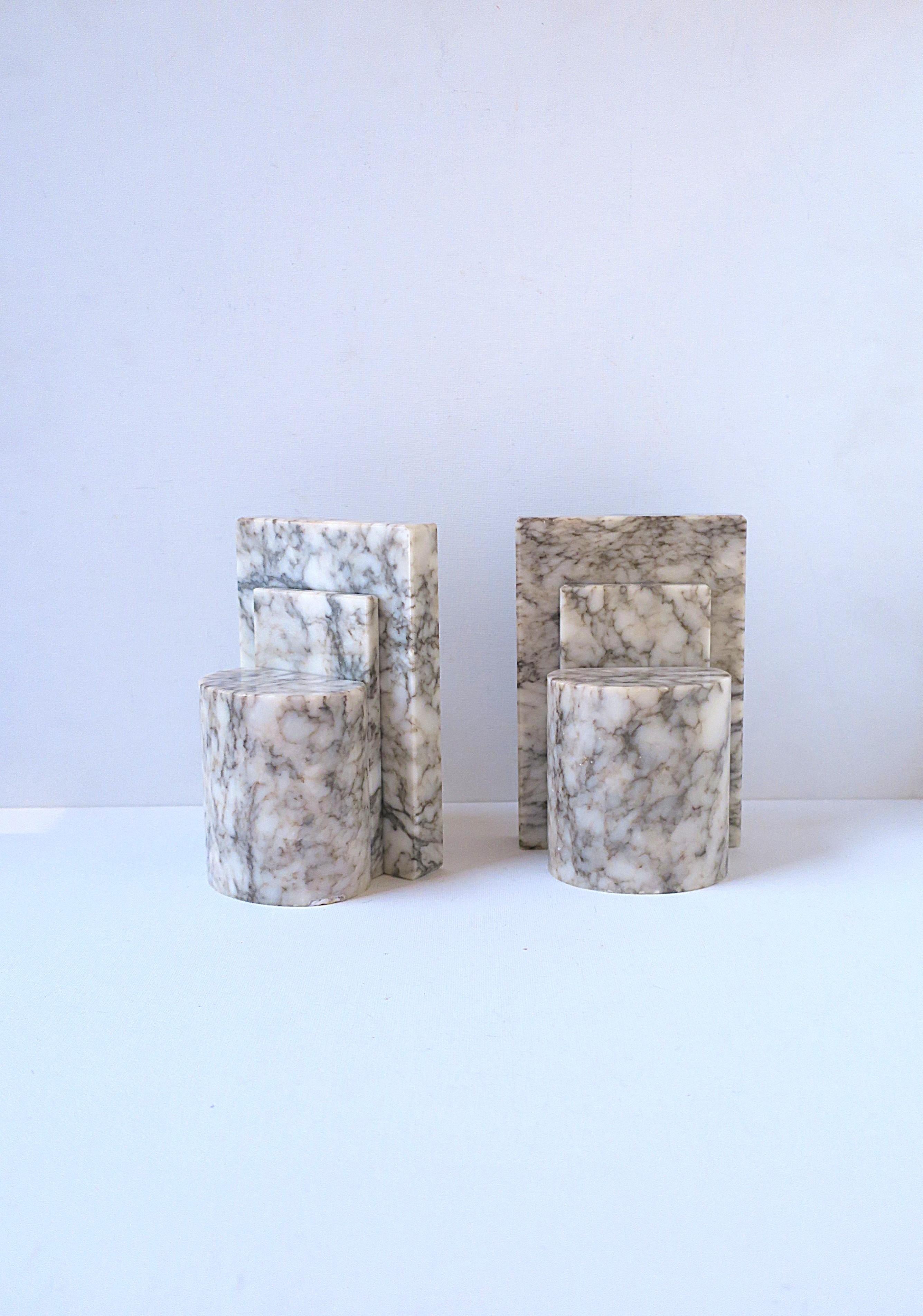 Pareja de sujetalibros italianos de mármol alabastro, diseño Art Déco Moderno, hacia mediados del siglo XX, Italia. Las parejas son de color blanquecino con vetas de color gris oscuro. 