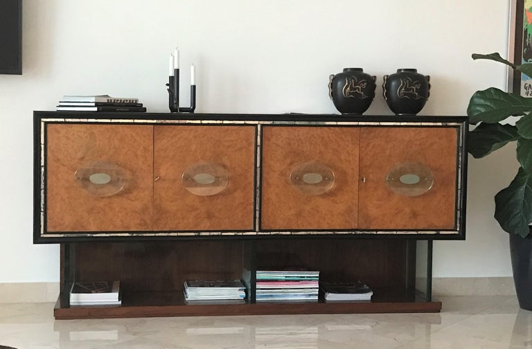 Superb and stunning Italian Art Deco Modern rosewood and Carpathian burl credenza cabinet with thick Fontana Arte glass handles and bottom supports. The body in Rosewood (Palisander) and ebonized wood with surrounding inset antique mirror strips and