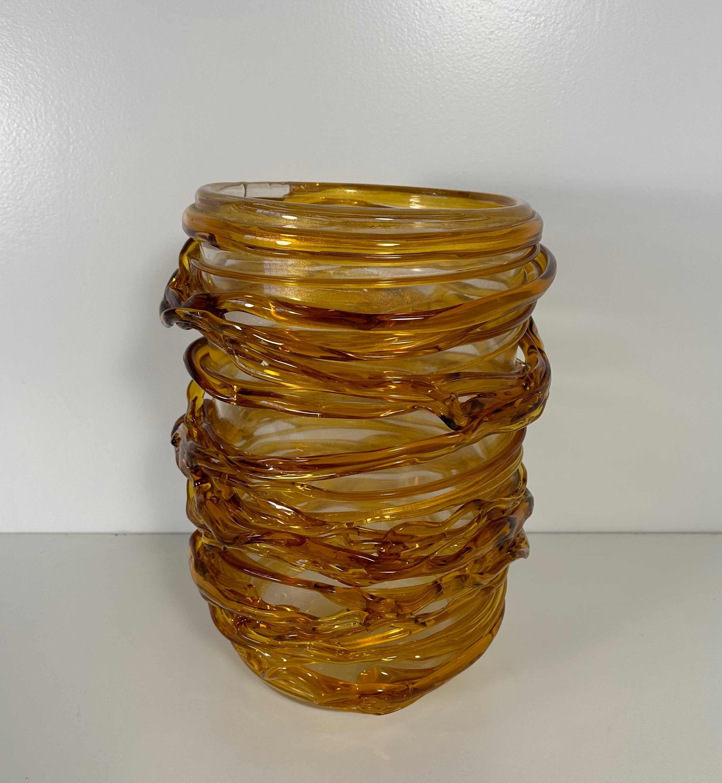 This unique vase was produced in Italy, more precisely in Murano, which is the world's capital of glass art making and crafting. 
It is completely made of amber colored Murano glass, which has been particularly and finely crafted to create