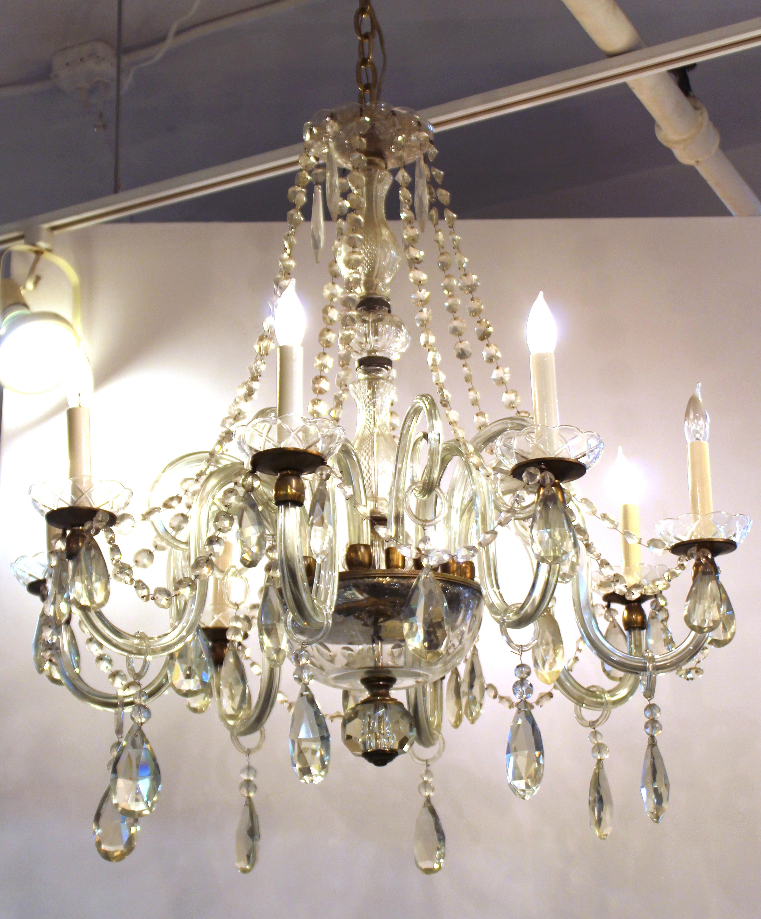 Italian Art Deco Murano crystal eight-light chandelier dated circa 1930s with swooping strands of crystal beads. Silver tone metal frame with a cut glass center shaft, etched glass bobeches with crystal drops and candle arms decorated with glass