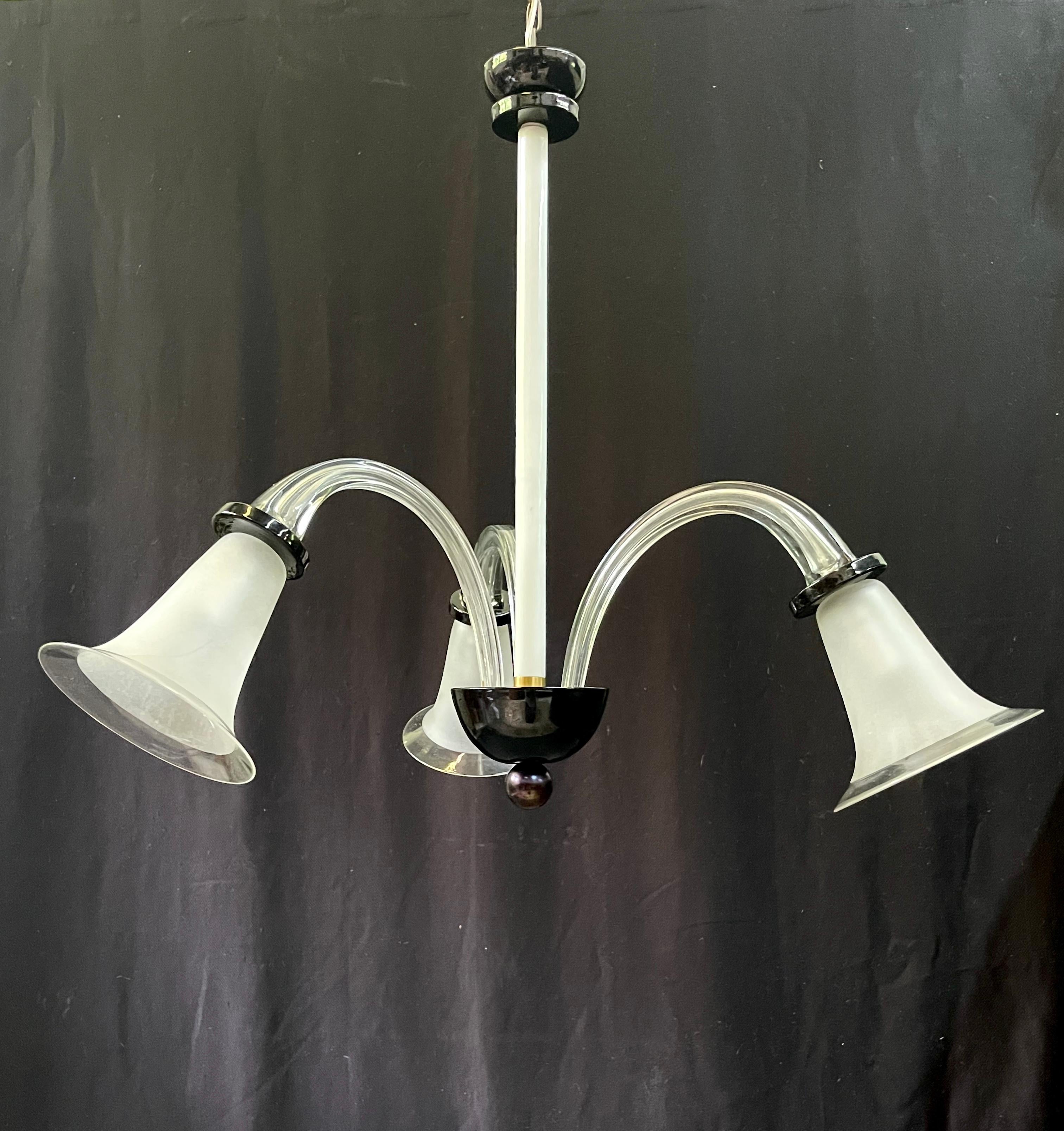 This mid 20th century Art Deco classic black and white Murano glass chandelier is characterized by its dramatic downward lights and superb simplicity. 

The three-light chandelier was made in Murano, Italy, around the 1940s. It is handcrafted of