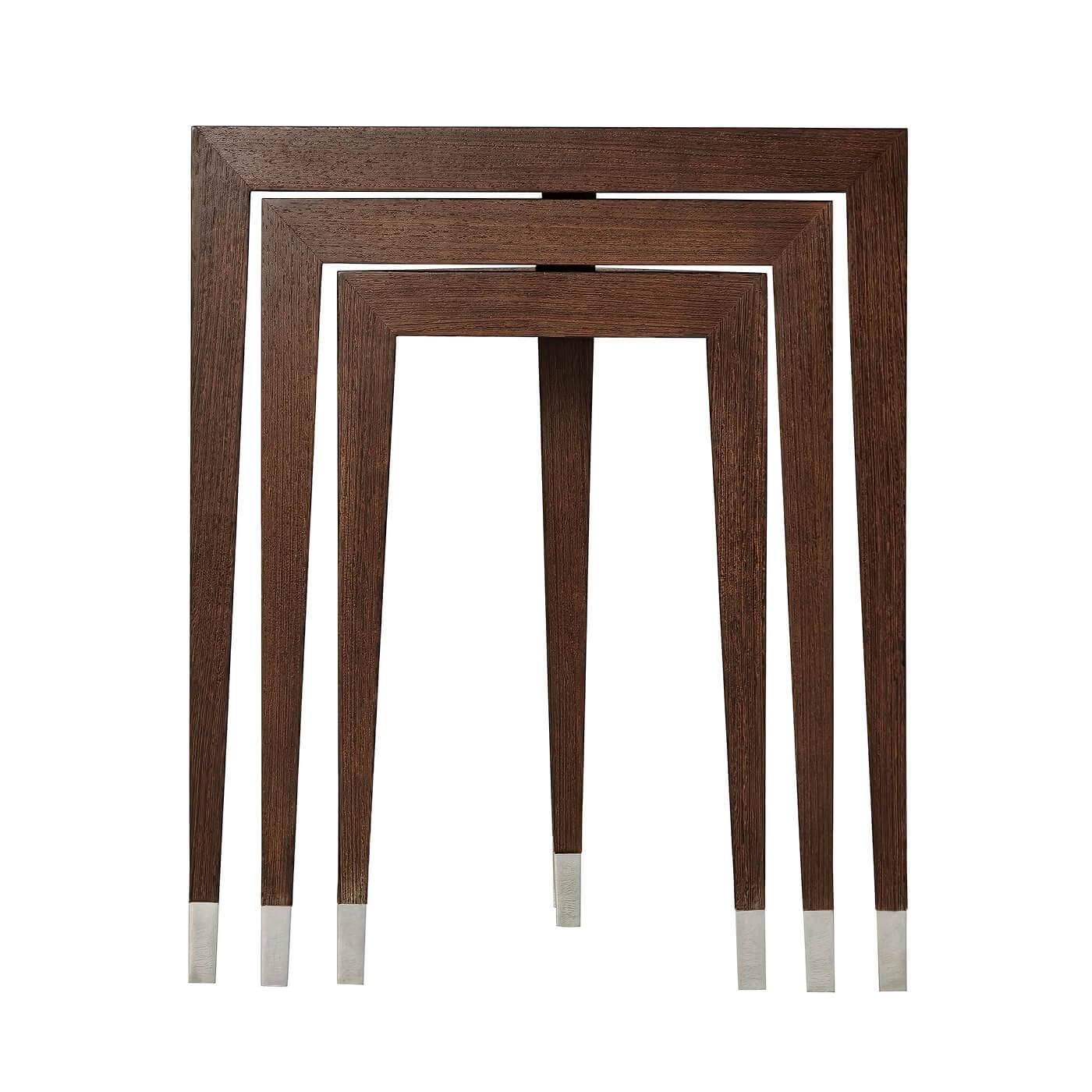 A nest of three Wenge veneer tables, each graduated table with a triangular top and tapering triangular legs with stainless steel feet. Inspired by Art Deco originals.

Dimensions: 20