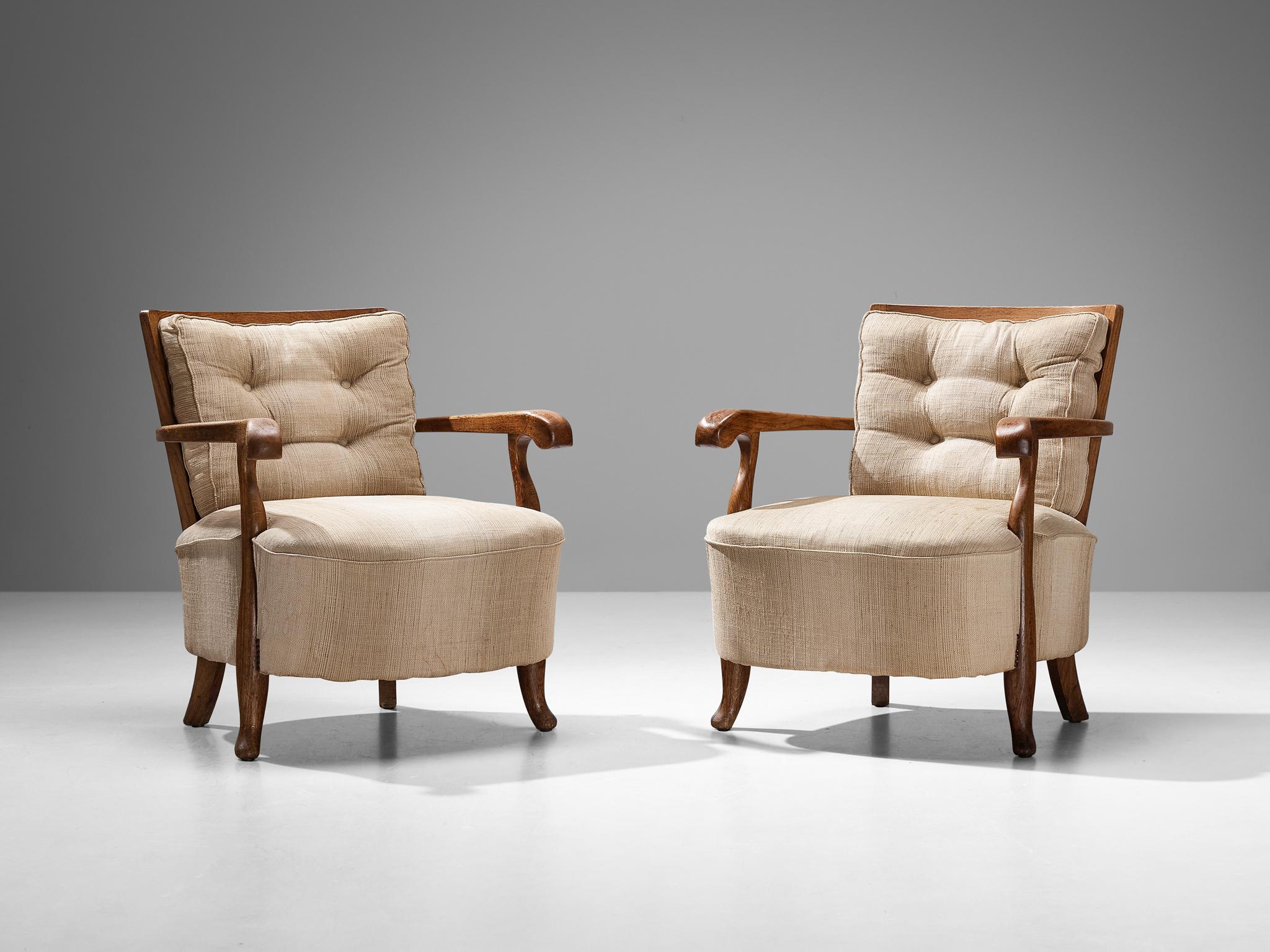 Pair of lounge chairs, oak, beige fabric upholstery, Italy, 1940s
 
Pair of Italian art deco lounge chairs with oak frames and remarkable proportions. The large upholstered seats and shorter rounded backrests form an inviting pair of armchairs