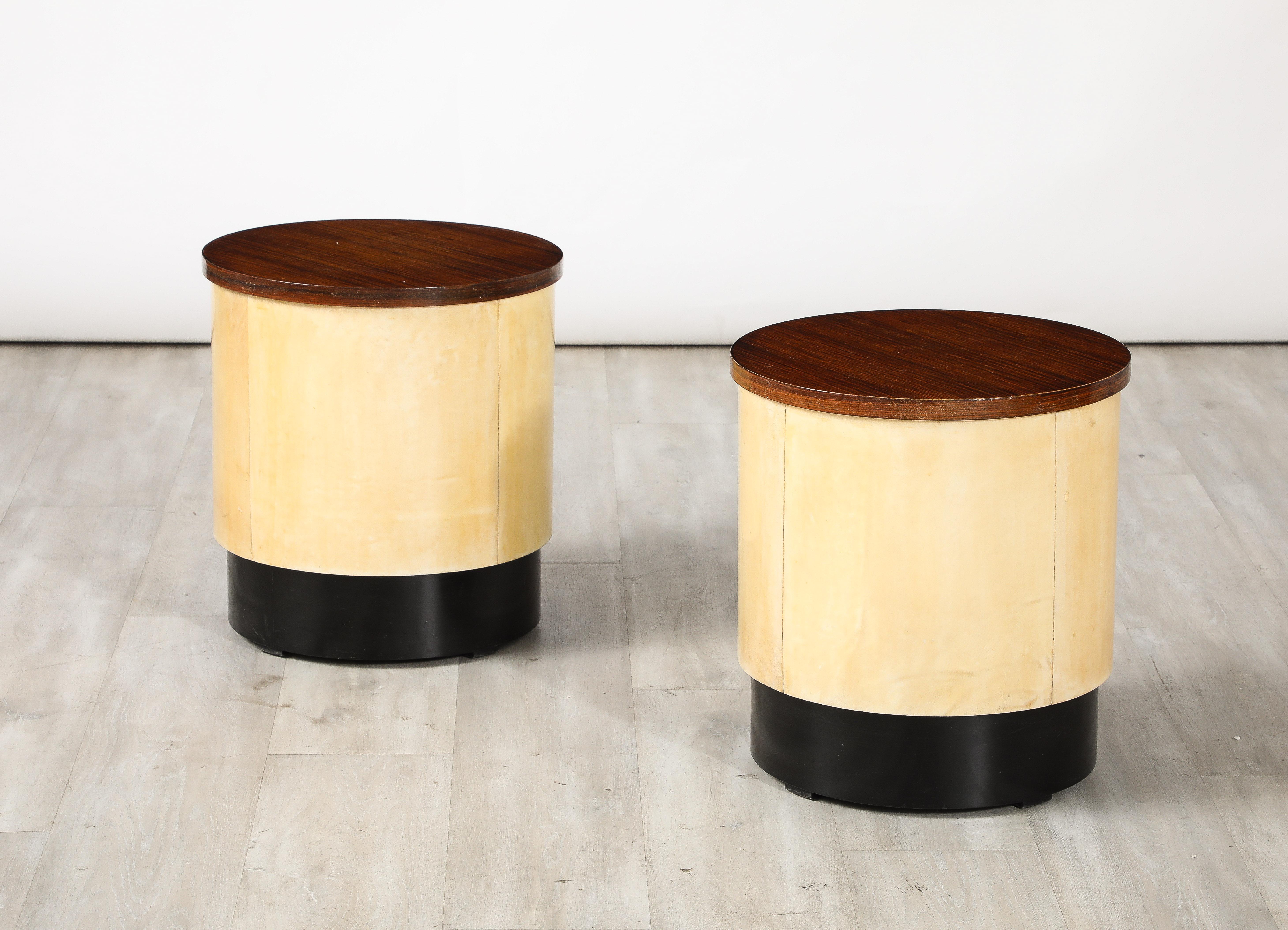 A pair of Italian Art Deco stools, the circular tops in palisander wood supported by rounded bases covered in vellum and the base surround in ebonized wood.  The combination of the exotic and rich palisander wood and warmth of the vellum make for a