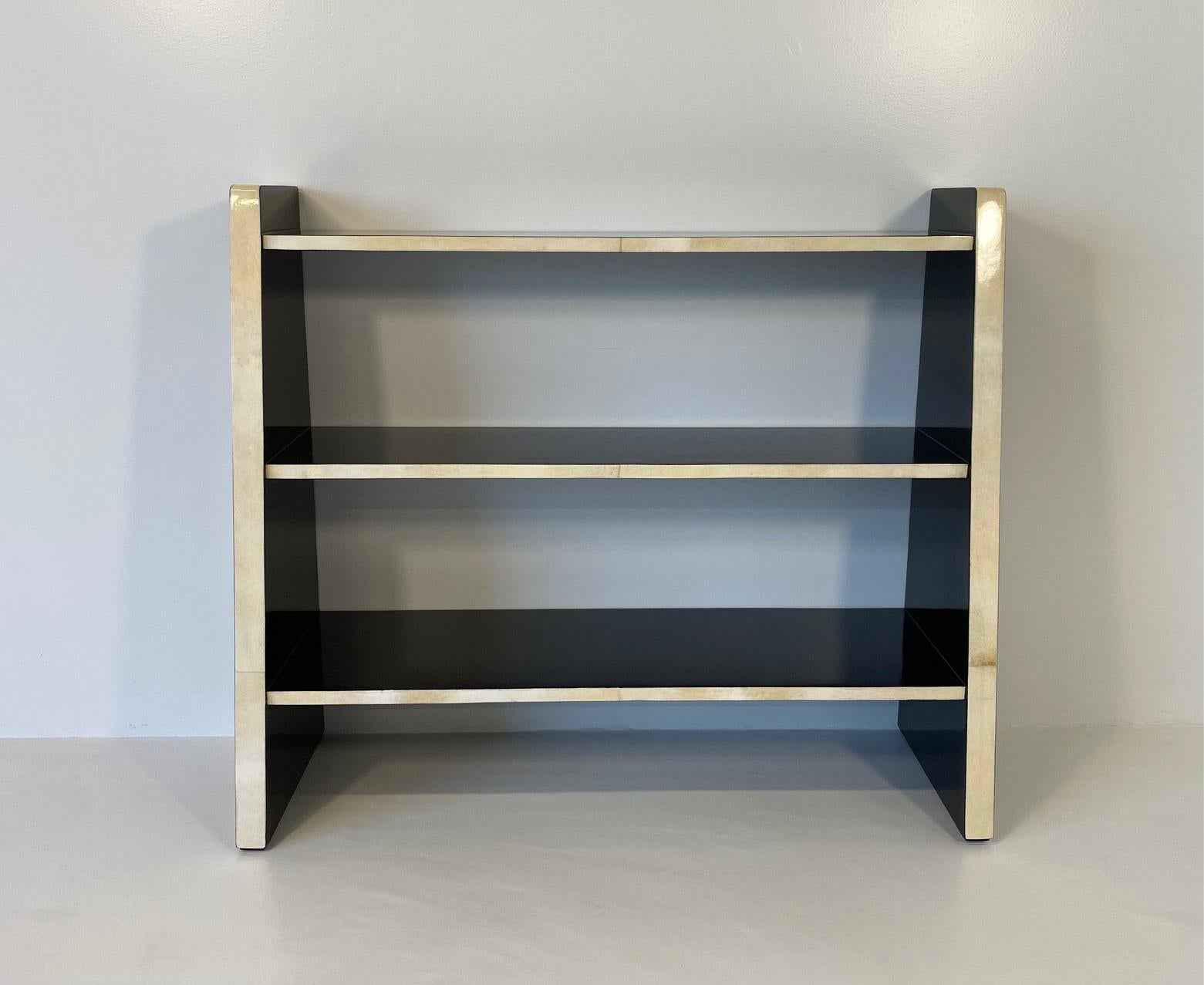 This beautiful Art Deco style bookcase was produced in Italy in the 1980s. 
 The structure is completely black lacquered, while the frontal profiles are in parchment. 
 It has been completely and finely restored in our laboratories.