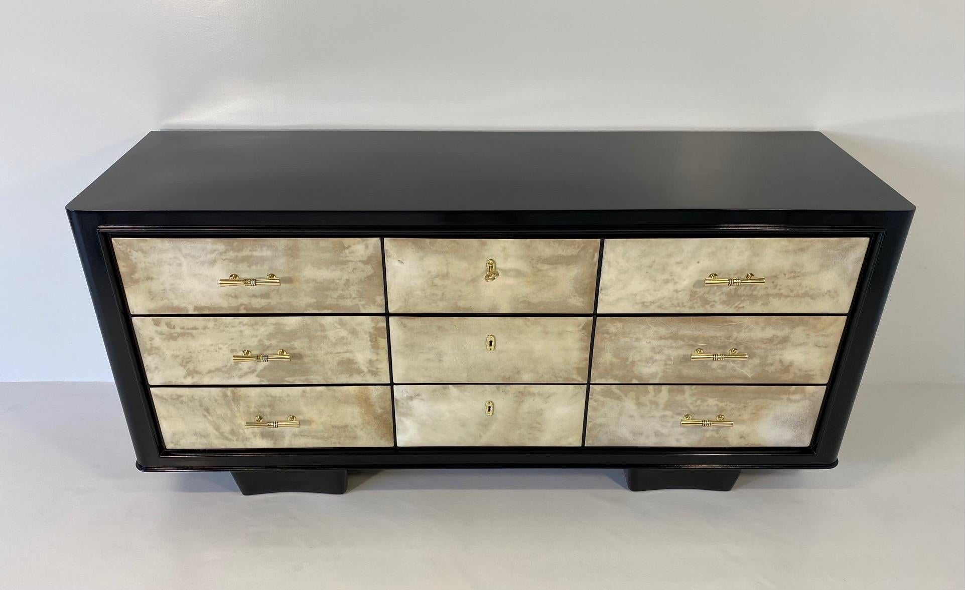 This elegant Art Deco dresser was produced in Italy in the 1940s.

It features nine parchment drawers, framed by a black lacquered structure. Handles, keyholes and keys are in brass.

Completely restored.
