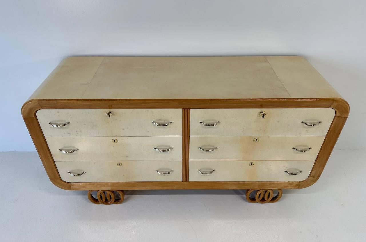 This beautiful Art Deco dresser was produced in Italy in the 1930s.
The top, the laterals and the drawers are in parchment, framed by a maple profile and legs. In the middle, the drawers are separated by a reeded maple line. 
The handles, the