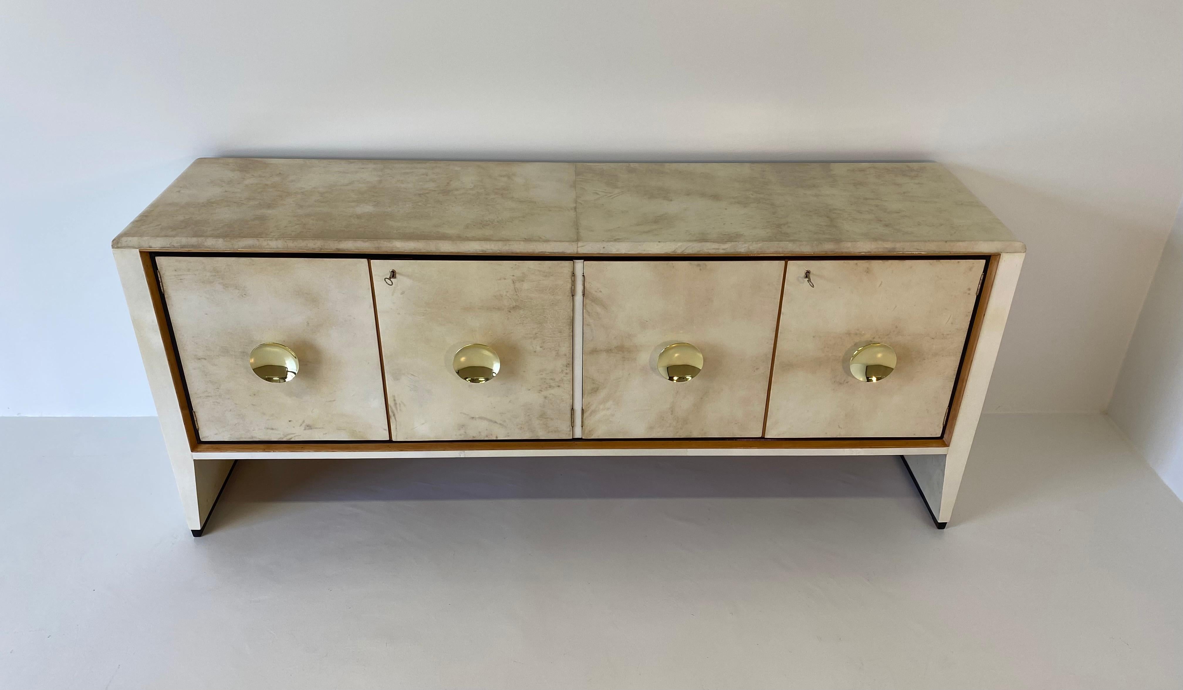 This fine and elegant Art Deco sideboard was produced in Italy in the 1940s and It is entirely covered in parchment.
The profiles are in solid maple wood and black lacquer.
The central handles are in brass.
Completely restored.