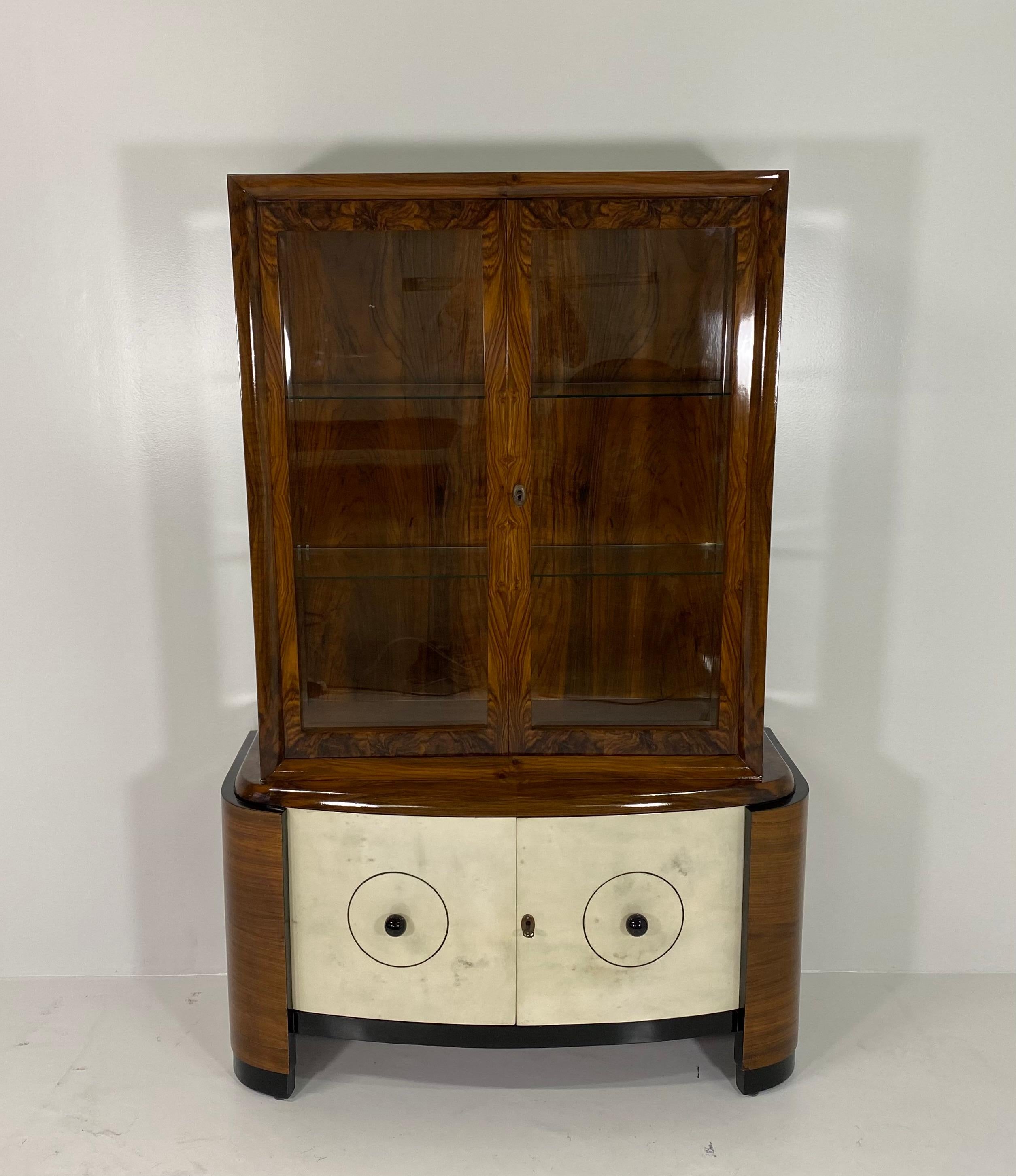 This vitrine bar or display cabinet is covered in precious walnut briar with details in black lacquered wood.
The two doors are covered in parchment while the two knobs are in black turned wood.
Completely restored.