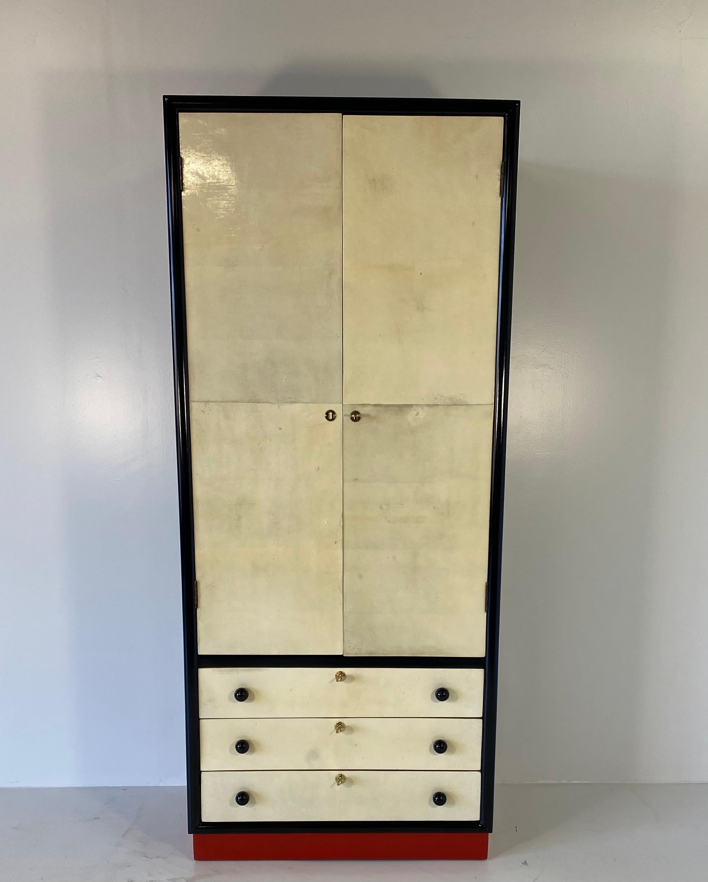 This precious and particular small wardrobe was produced in the 1930s in Italy.
The front of the doors and the drawers are covered in parchment while the structure is black lacquered.
The base is in red lacquer, the knobs are in turned solid