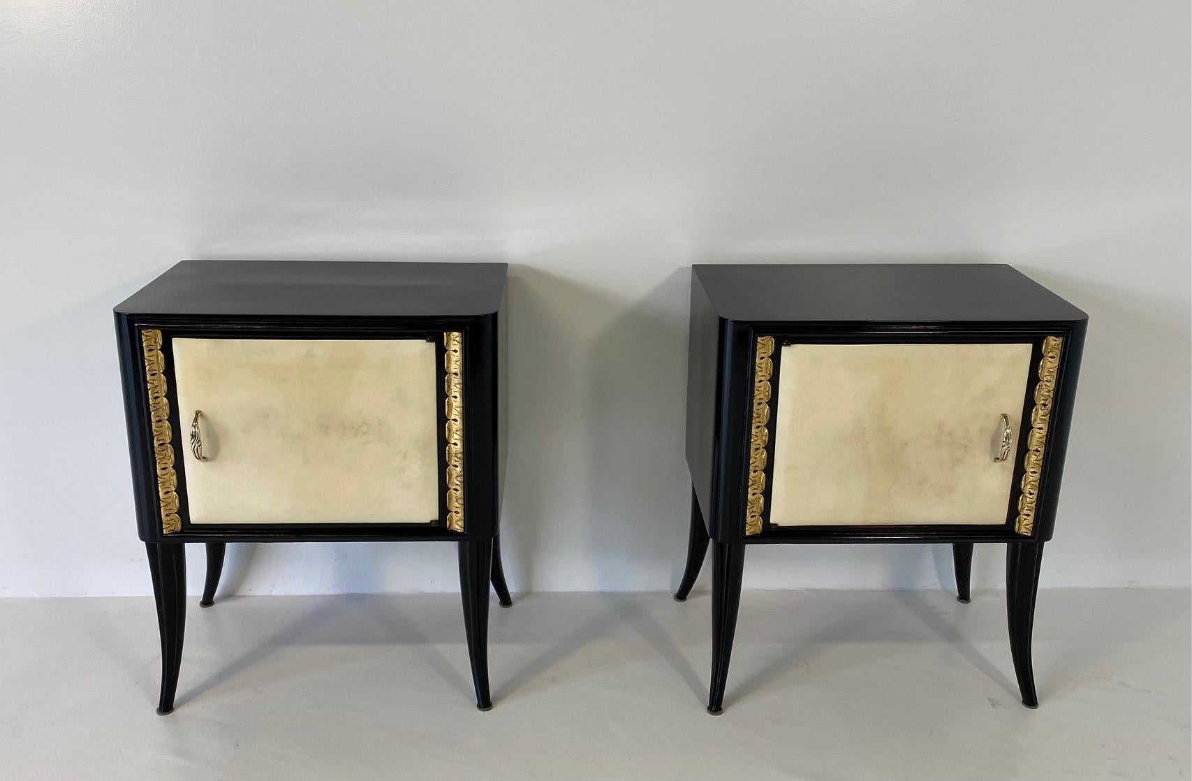This Art Deco nightstands were produced in Italy in the 1940s.

They features one parchment covered door each, a black lacquered structure and gold leaf decorations. 

The handless are in brass.

Matching dresser available. 

Completely restored.