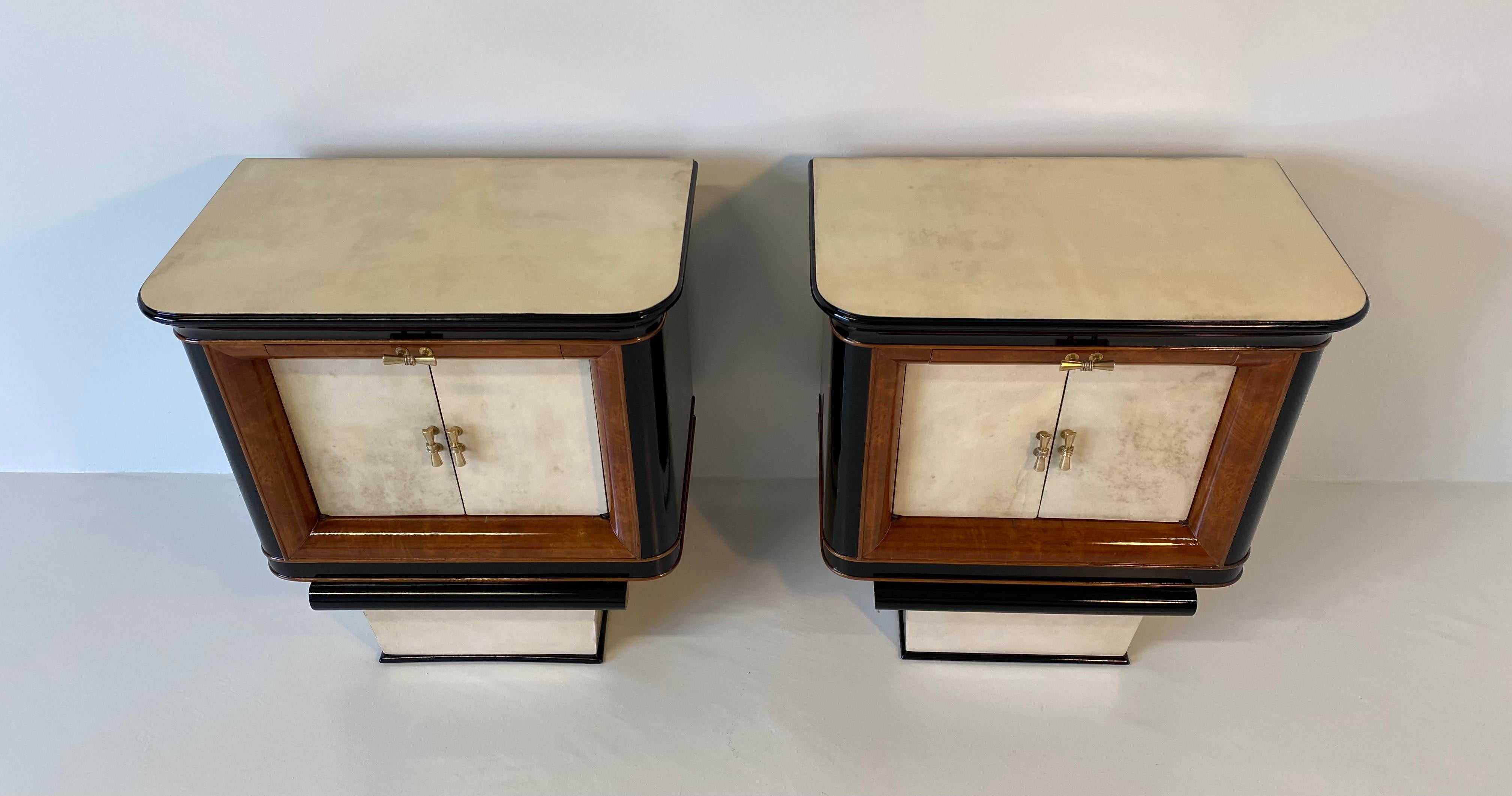 Italian bedside tables from the 1930s produced in Italy.
The front of the doors, the base and the top are in parchment while the profiles are in briar of myrtle.
The structure and the details are in black lacquered wood.
The handles are in
