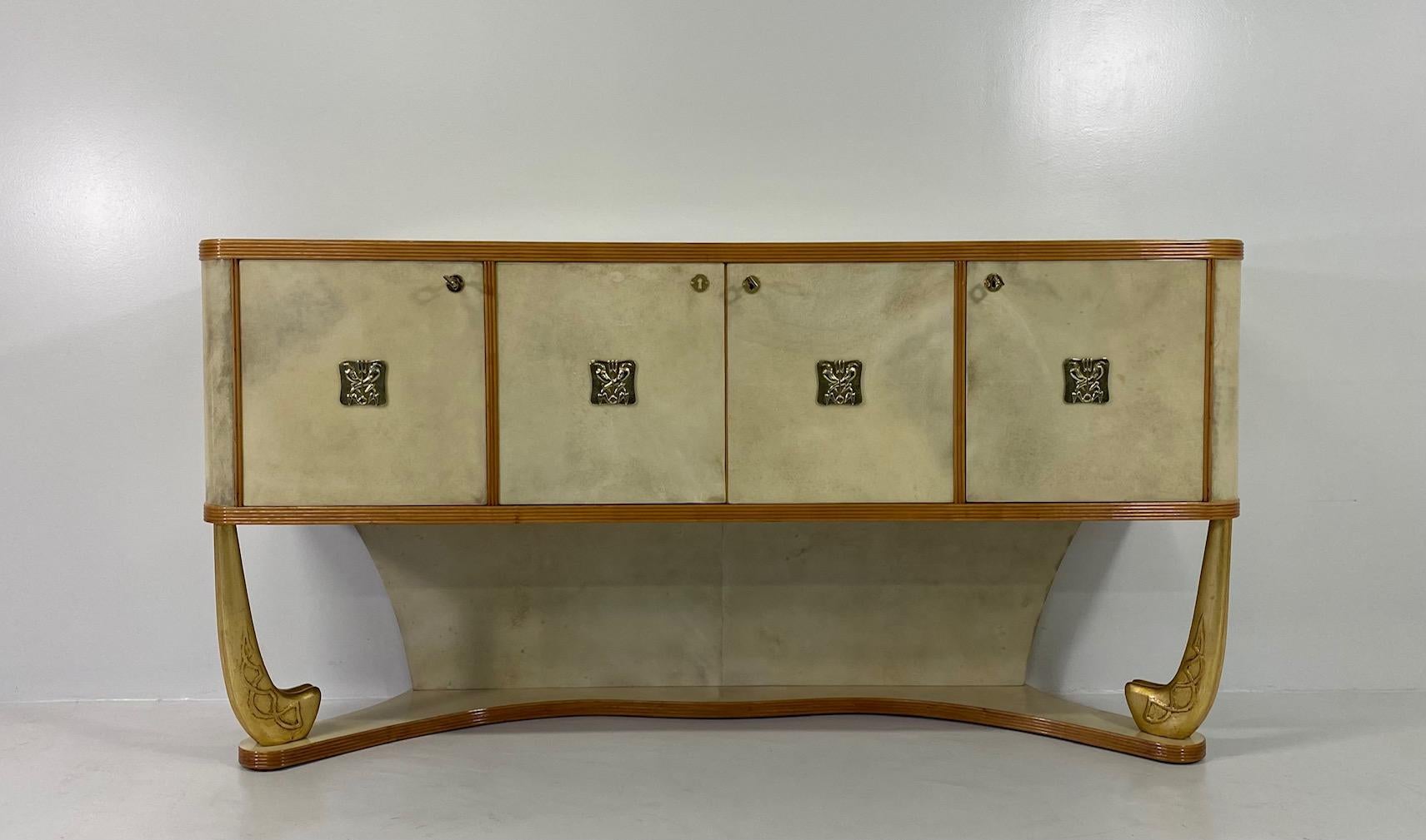 This Art Deco sideboard was produced in Italy, more precisely in Torino on a design by Pierluigi colli in the 1930s. 
The top, the background of the base, the doors and the laterals are in fine parchment, which is framed by maple profiles. The
