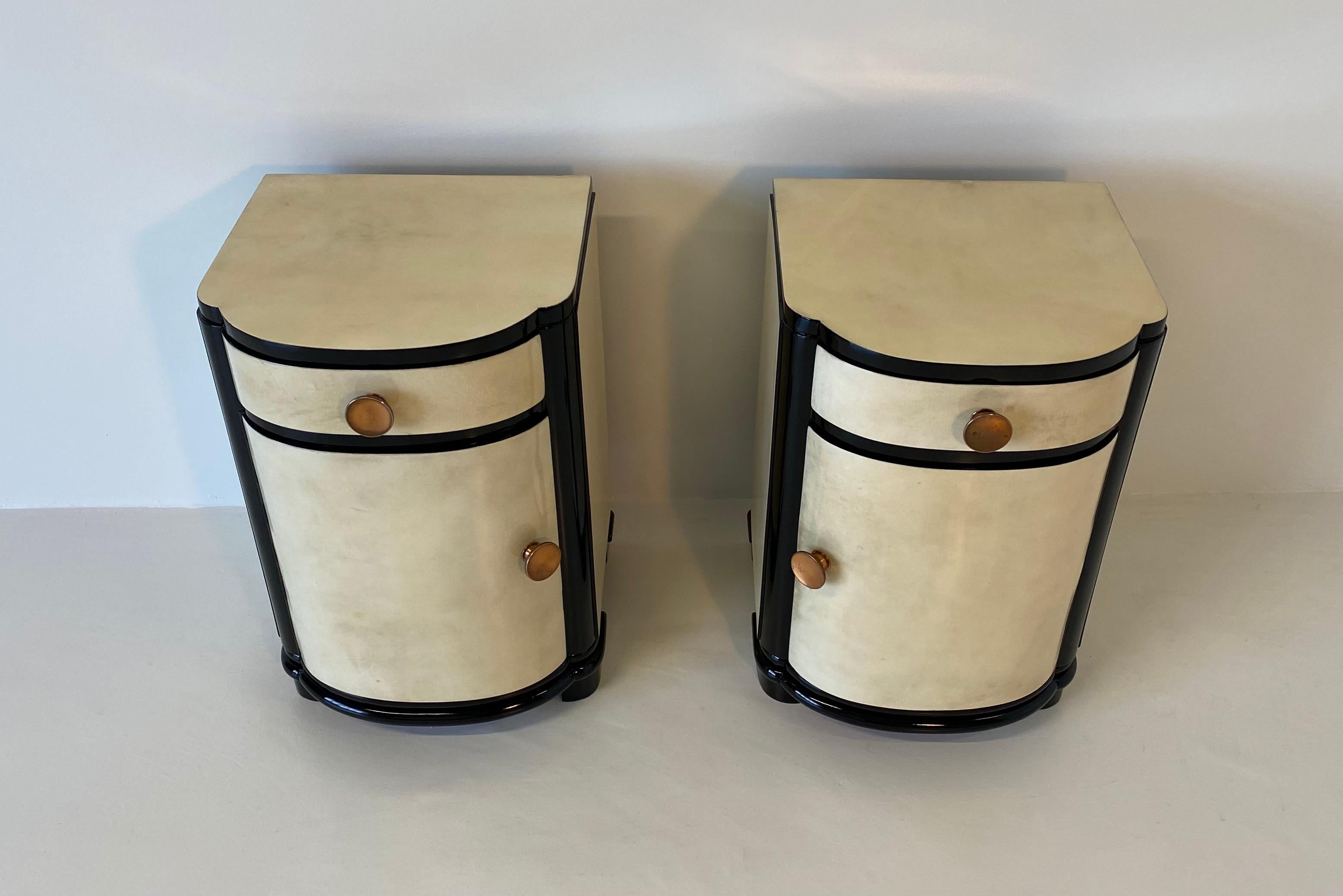 Rare Italian bedside tables from the 1930s completely covered in parchment.
The profiles and legs are black lacquered while the handles are in copper.
Fully restored.