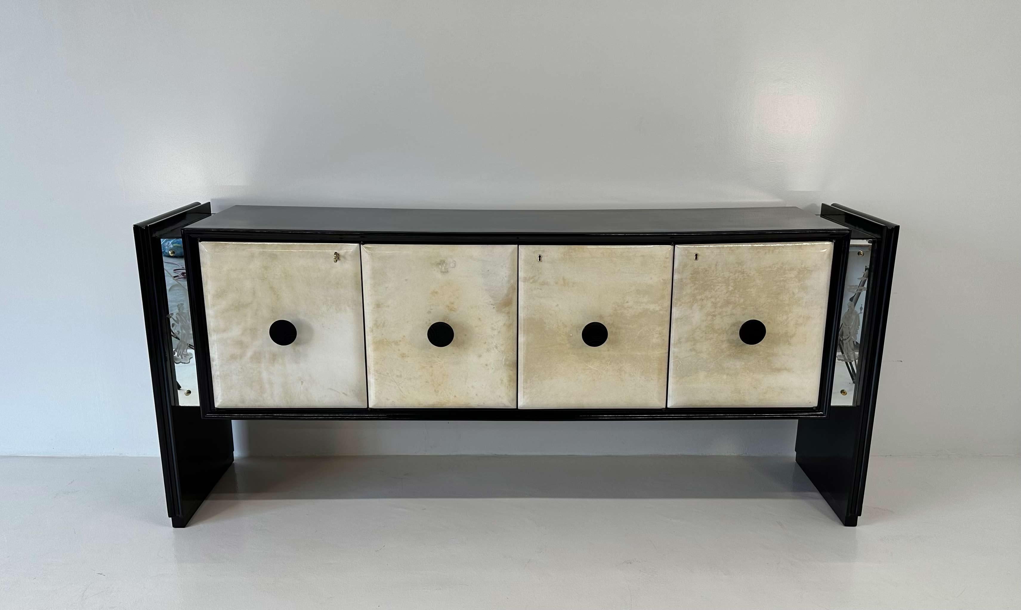 Este aparador Art Déco se fabricó en Italia en la década de 1940. Las patas, la encimera y los perfiles están lacados en negro, mientras que las puertas son de pergamino. 
Las decoraciones son de espejos arenados, que representan temas típicos del