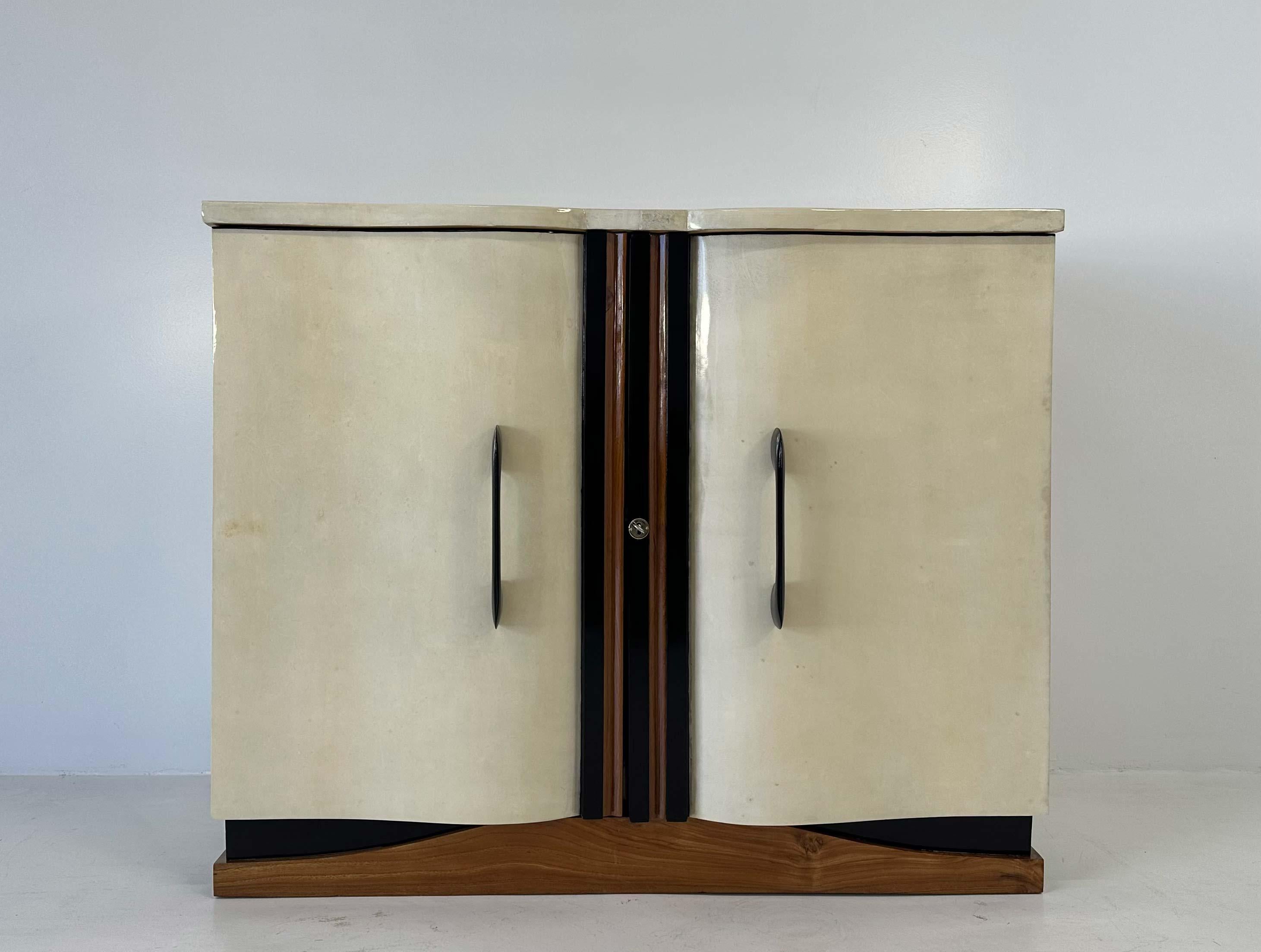 This stunning Art Deco cabinet was produced in Italy in 1936 circa and it is attributable to Guglielmo Ulrich. 
The laterals, the top and the sinuous doors are covered in parchment (goat skin), one of the most used material by Guglielmo Ulrich. The