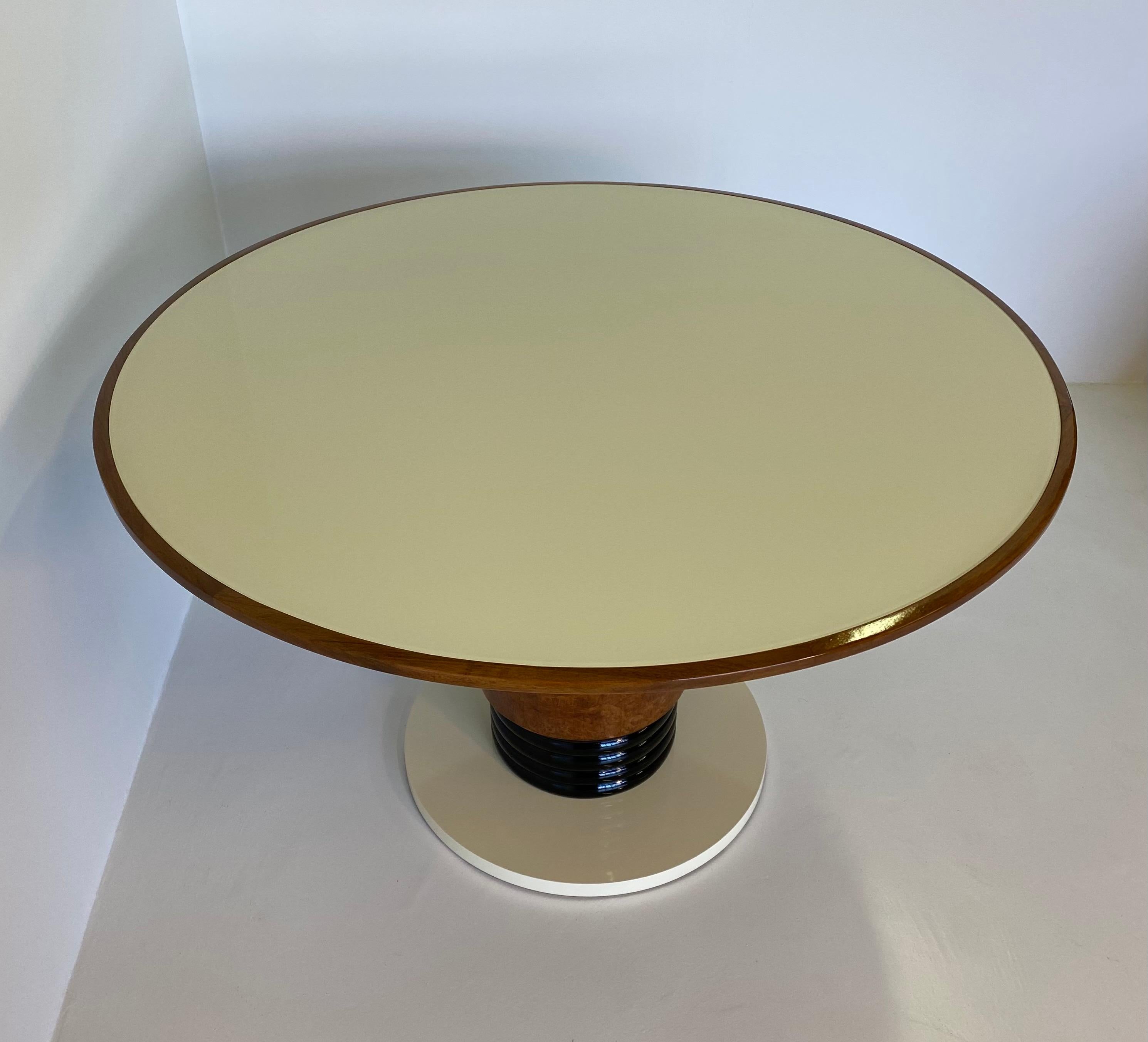 This fine Art Deco table was produced in Italy in the 1930s.
The cylindrical base is made up of a top in ivory lacquered wood, a central part in turned solid wood and black lacquered and a part in precious maple burl.
The top is in solid walnut