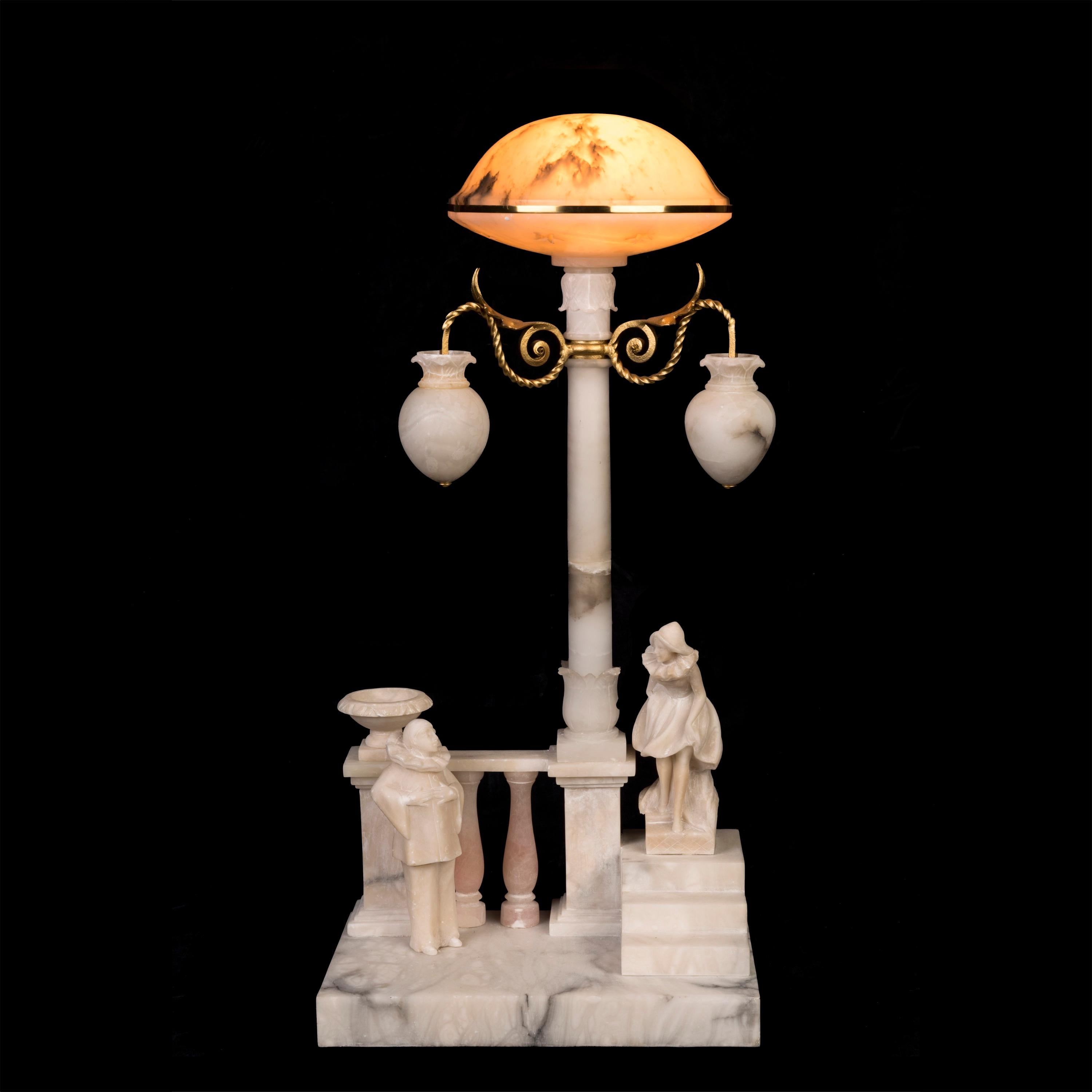 Lampada da tavolo in alabastro figurato in stile Art Déco italiano
di Pierrot e Colombina

Ispirata alla famosa Commedia dell'arte, la lampada in alabastro scolpito a mano ha la forma di un lampione con lanterne sospese da bracci in ottone sotto i