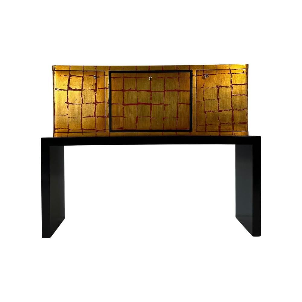 Ce meuble de bar particulier et rare a été produit dans les années 1940 en Italie.
Il est entièrement laqué rouge avec un décor à la feuille d'or qui rend ce meuble unique.
Le profil, la base et le dos fini sont laqués noir.
Entièrement restauré. 
