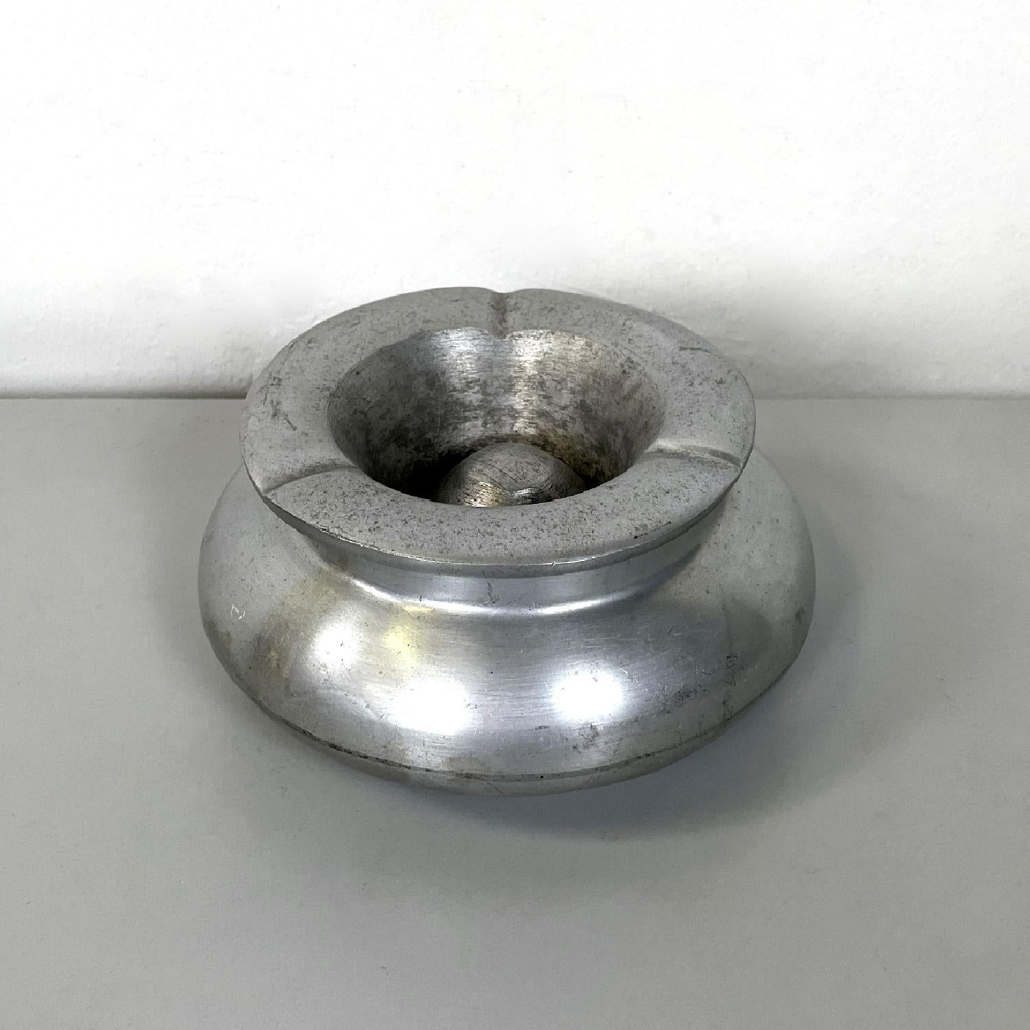 Italian Art Deco round aluminum ashtray with removable top, 1930s
Round ashtray entirely in aluminium. It has rounded lines that descend towards the bottom, to reach a small step on the ground. The upper part is removable and has three recesses for