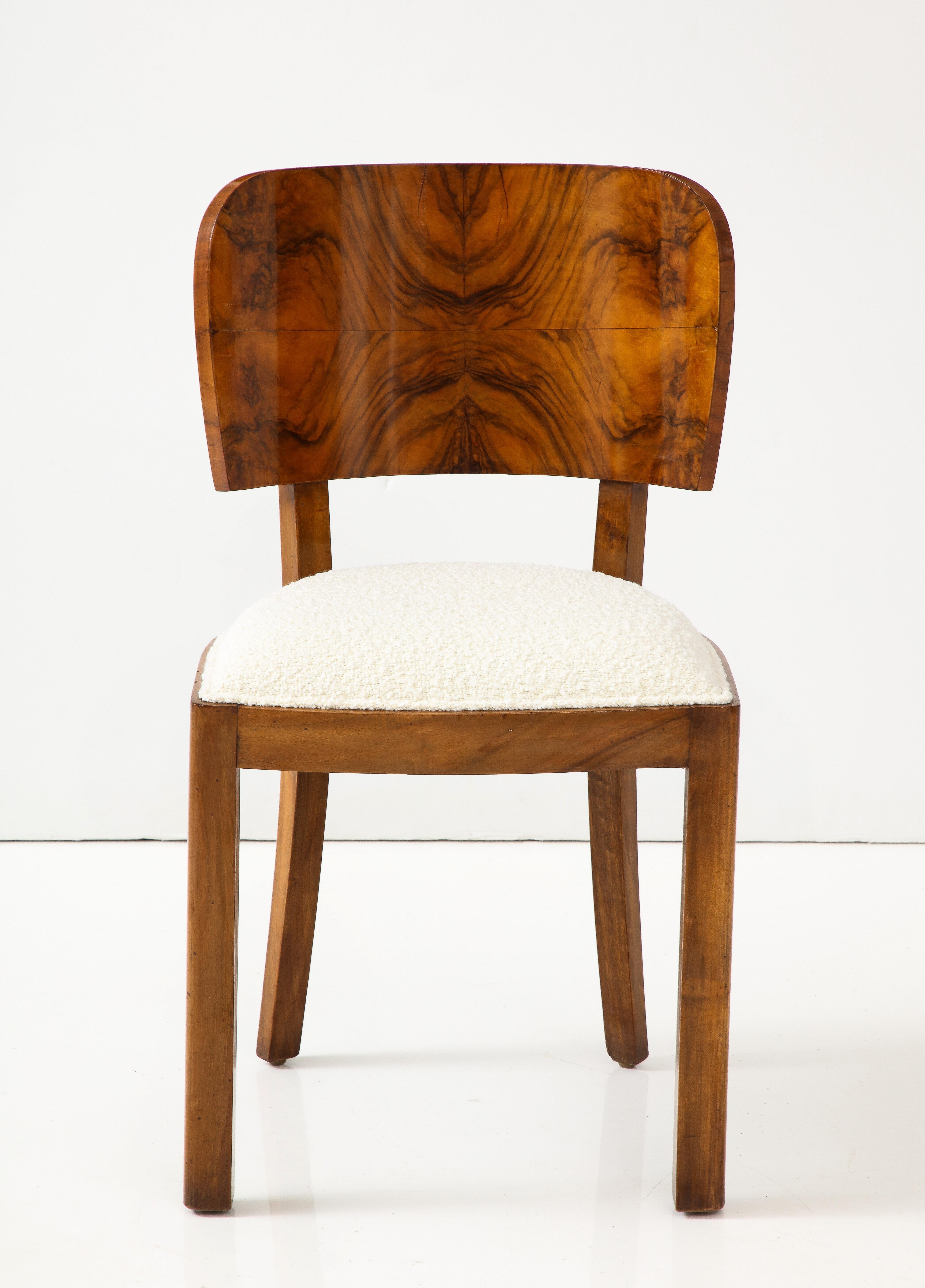 Italian Art Deco set of eight dining chairs; with molded back rests and straight legs, in a stunning burl wood and walnut.  Newly restored and re-upholstered in a creamy boucle. 
Florence, Italy, circa 1940 
Size: 34 1/4
