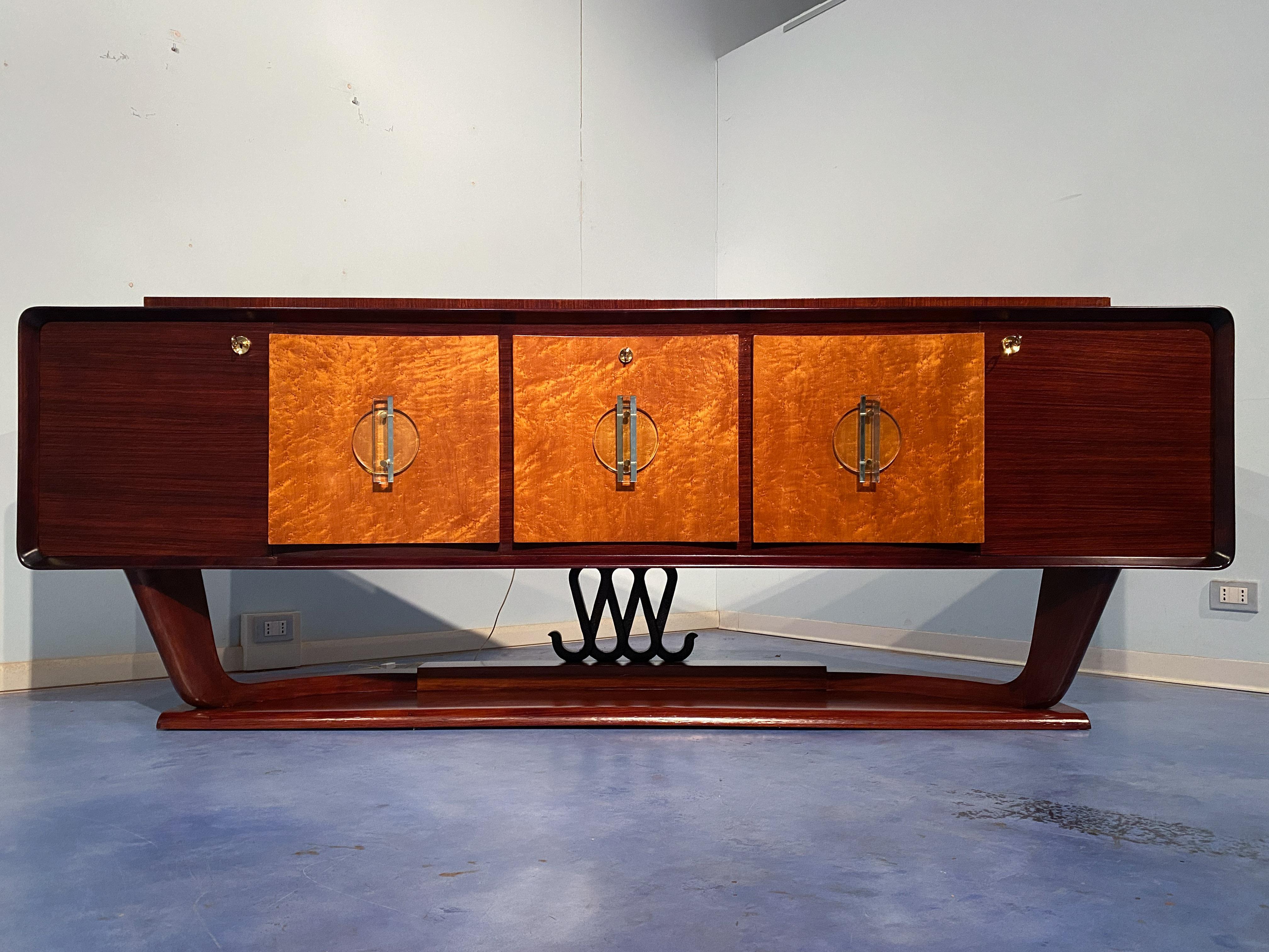 Osvaldo Borsani designed this beautiful Italian sideboard in the 1940s. With its unique design and excellent manufacturing quality, the sideboard stands out from the crowd.

The glass handles on the three central doors are magnificent. The slight