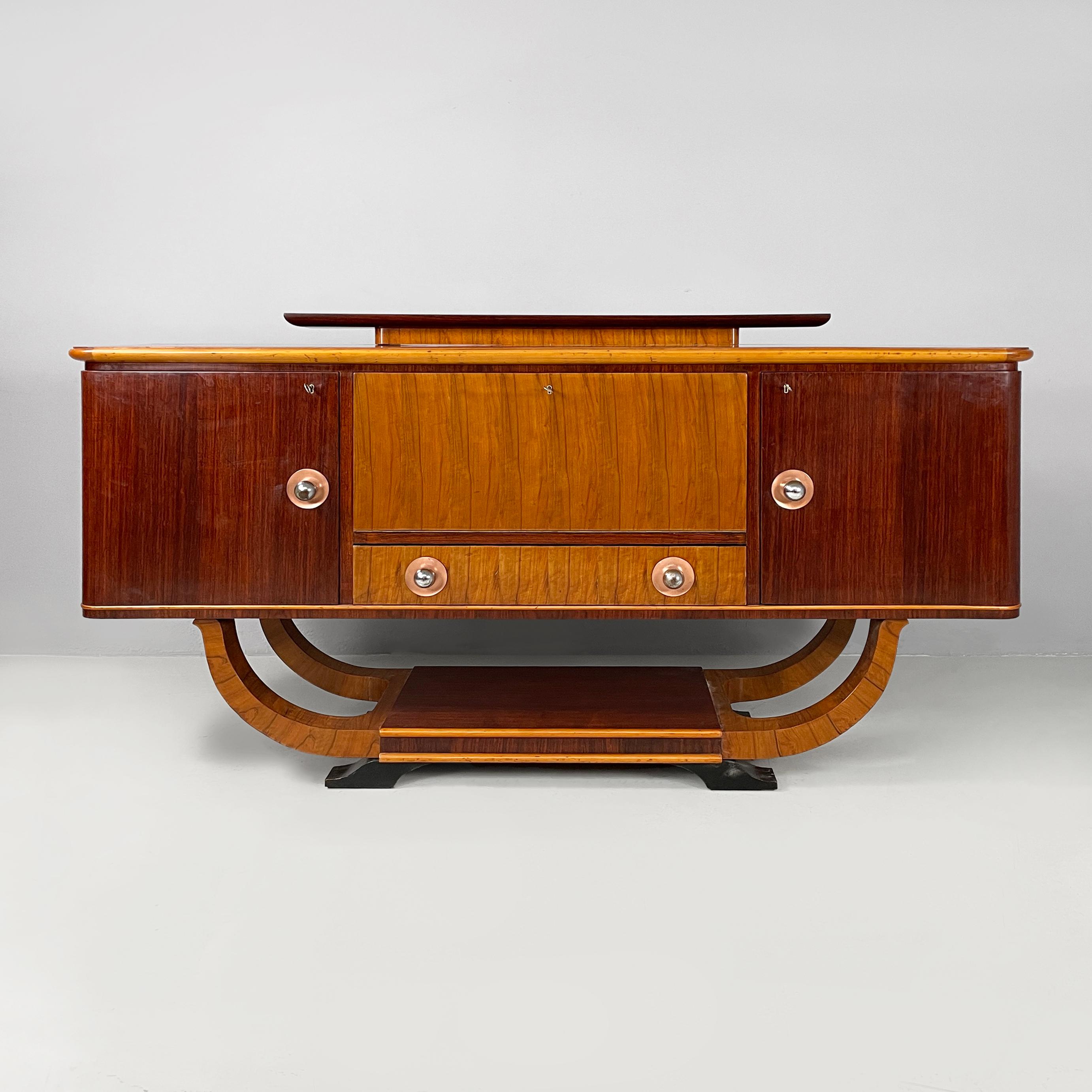 Italian Art Deco Sideboard with bar compartment in wood, 1920s
Rectangular-based sideboard with rounded front corners, in light and dark wood. On the top there is a raised shelf, also with rounded corners. On the sides there are two compartments