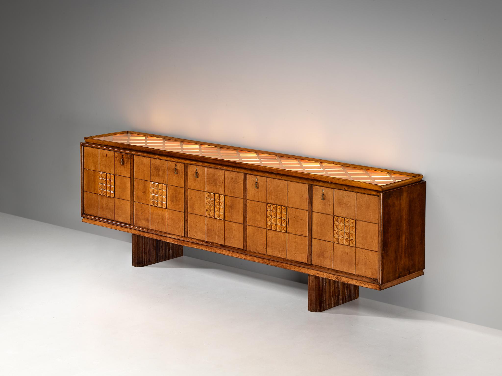 Sideboard, walnut, maple, glass, Italy, 1940s

This truly remarkable credenza is from Italy, showcasing its excellence in composition, material use, and intricate detailing. The front is adorned with square panels, with small carved tetrahedrons at