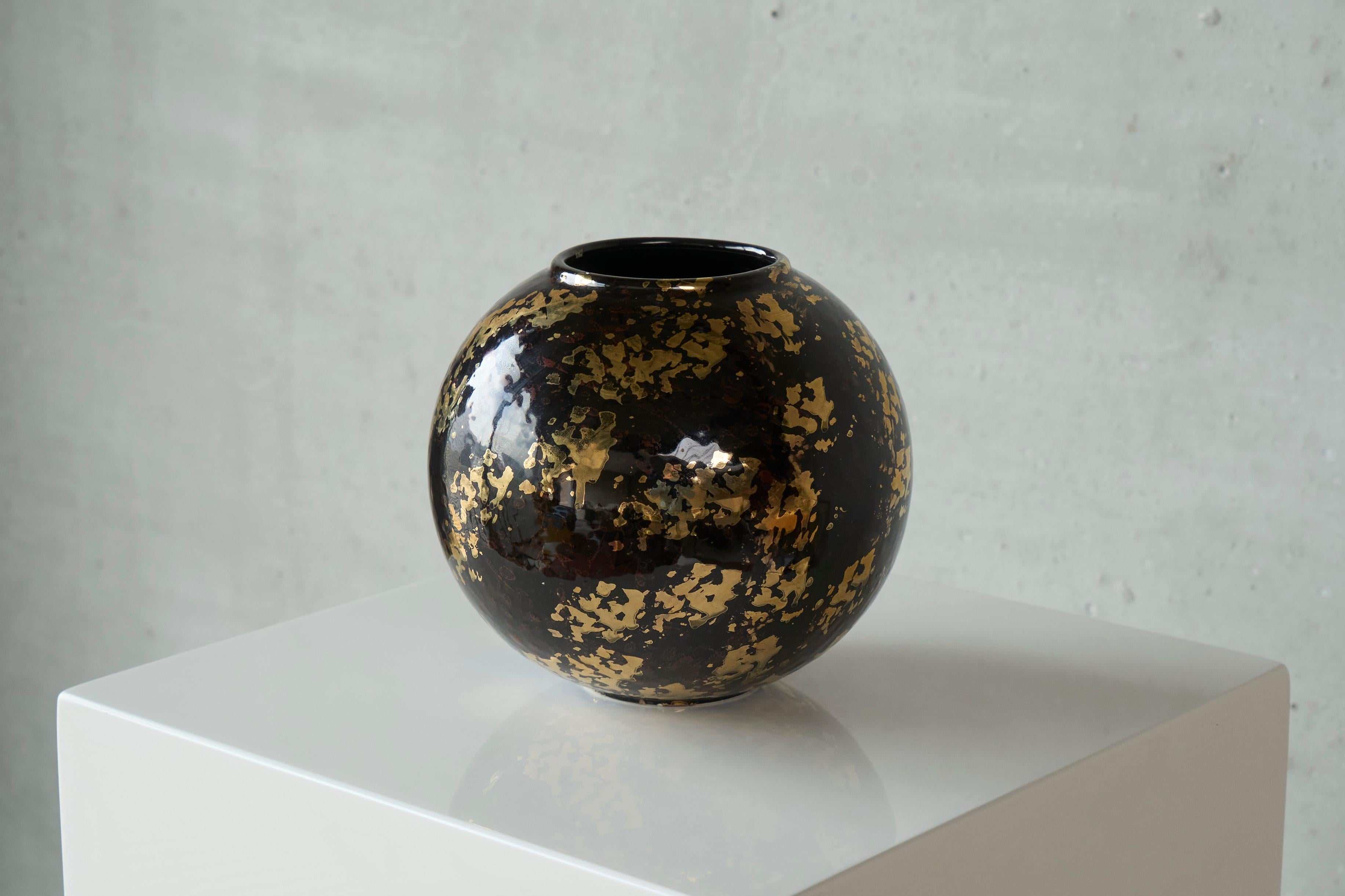 Vase en poterie italienne Art Déco Studio avec paillettes d'or 1940s.

Voici un magnifique vase rond en poterie d'atelier art déco avec une très belle glaçure noire et des paillettes d'or. Très élégant et intemporel, ce vase s'intègre parfaitement