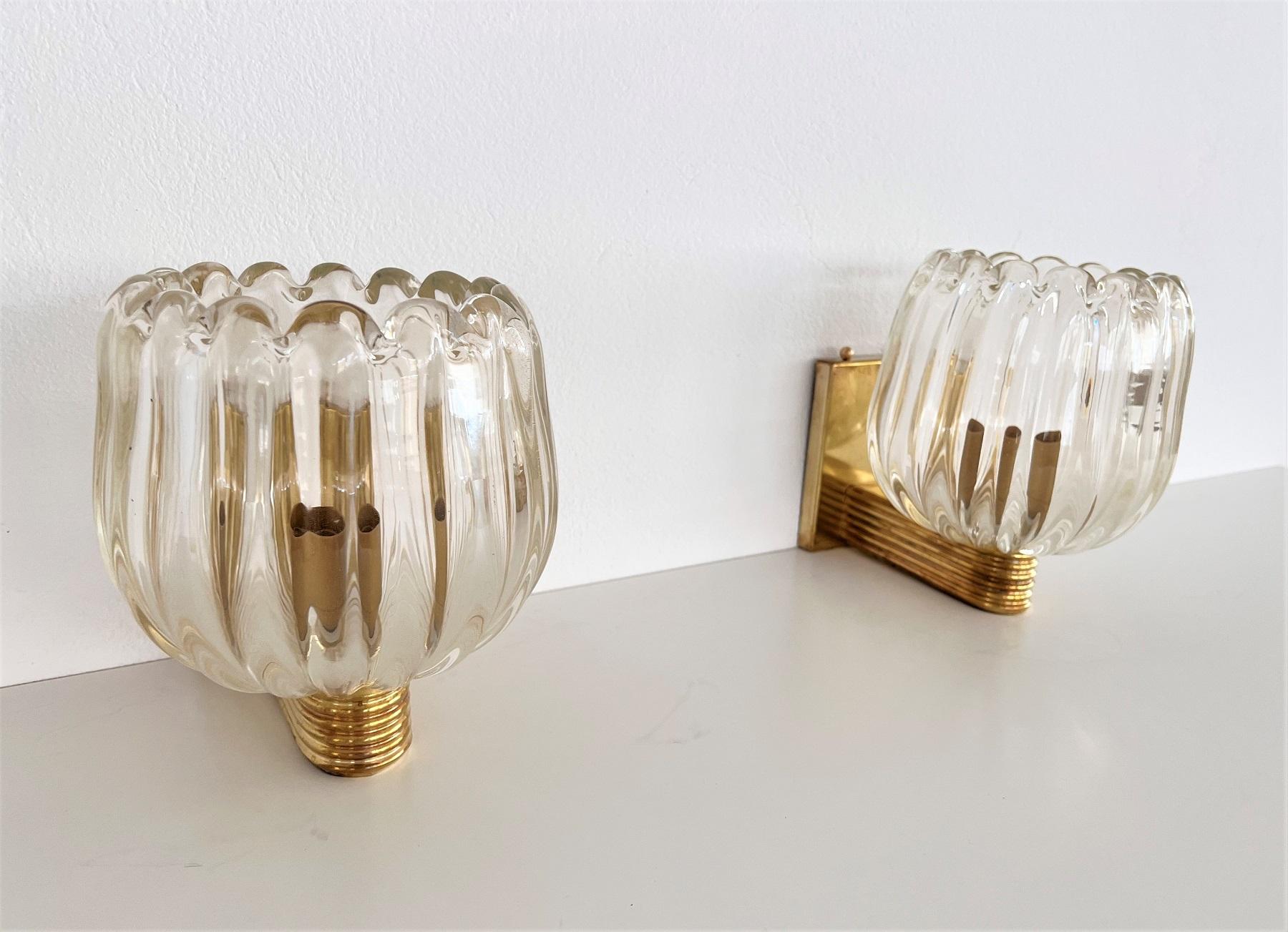 Beautiful set of two gorgeous brass wall lamps made of strong brass base and light amber-transparent Murano glasses with golden shimmer/glitter inside the glass.
Made in Murano, Venice, Italy.
Art Deco style.
The brass is partially with gorgeous