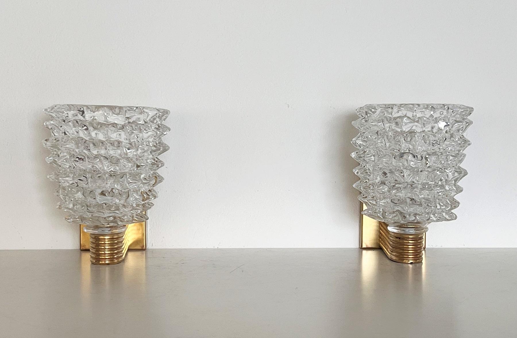 Beautiful set of two gorgeous heavy wall lamps entirely hand-crafted in Murano made of clear Murano glass in rostrato technique.
The glasses are fixed on hand-crafted brass base.
Made in the Art Deco style of Barovier and Toso.
The brass is with