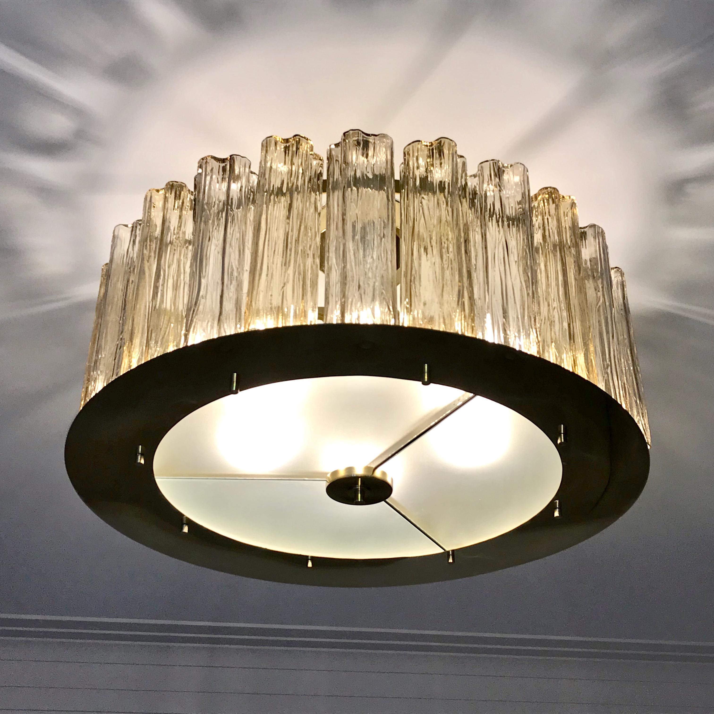 A contemporary Italian bespoke modern chandelier, entirely handcrafted in Italy, customizable as flushmounts or pendants with different colors and finishes, here with a brass structure in a geometric circular shape, highlighted and made precious by