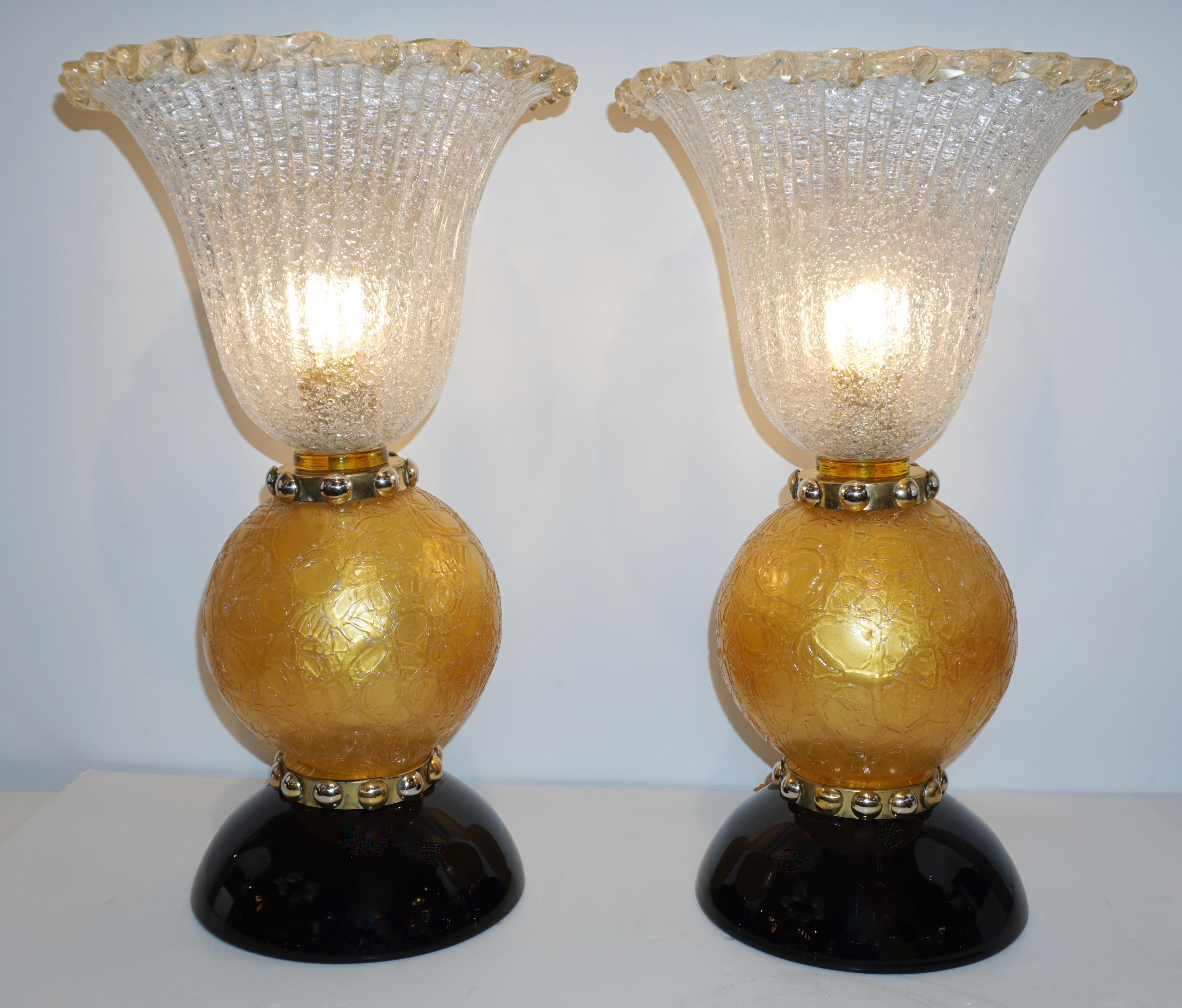 These lamps with Art Deco Design and Hollywood Regency flair are an exclusive vintage creation of the 1970s. The organic rounded design is enhanced by details of high quality craftsmanship: the bodies consist of crystal clear overlaid Murano glass