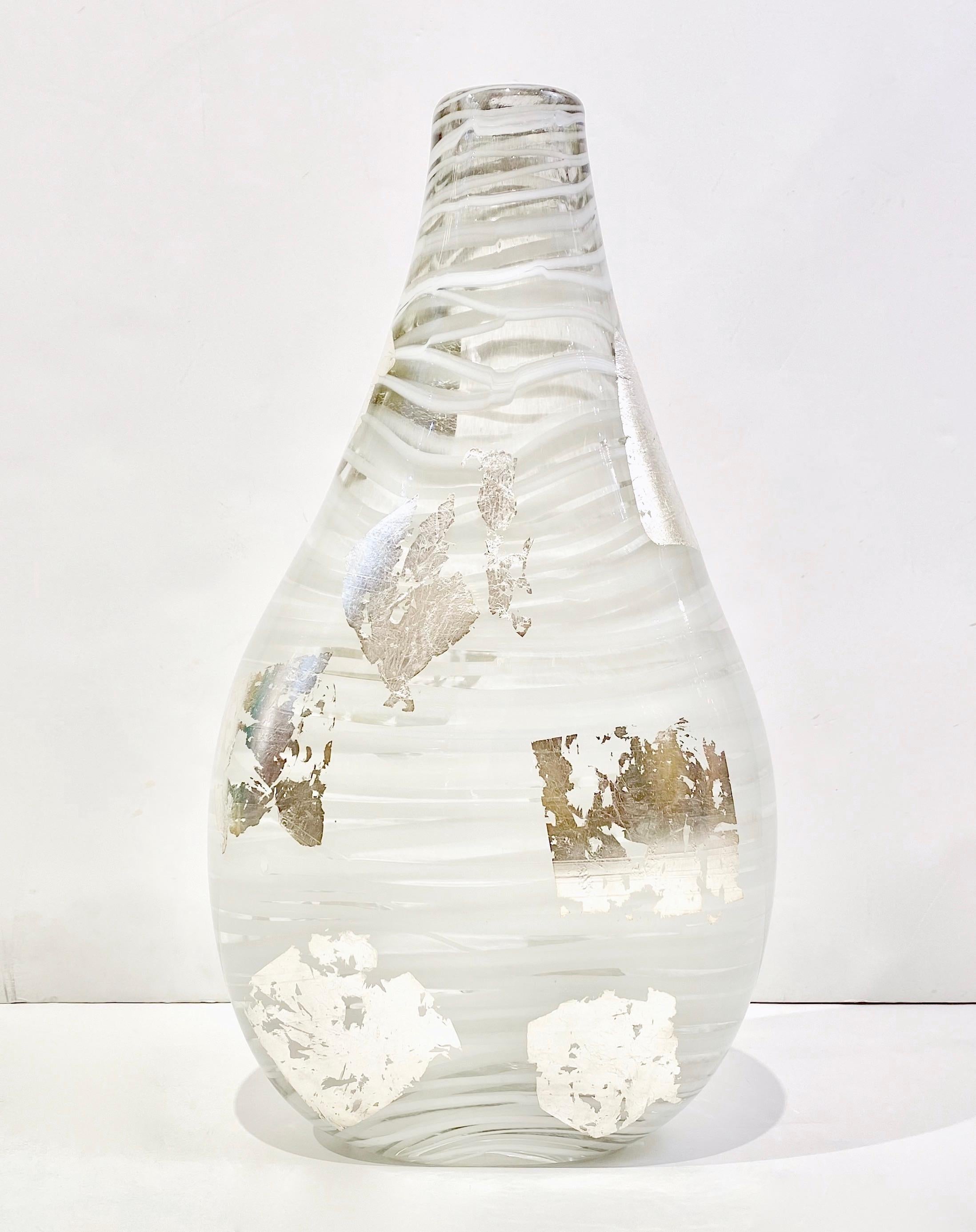 Elegant Minimalist organic creation, crystal clear thick blown Murano glass sculptural flower vase, decorated with white threading Filigrana wrapped around the drop shape, creating a fascinating abstract modern design. Le corps est rendu précieux