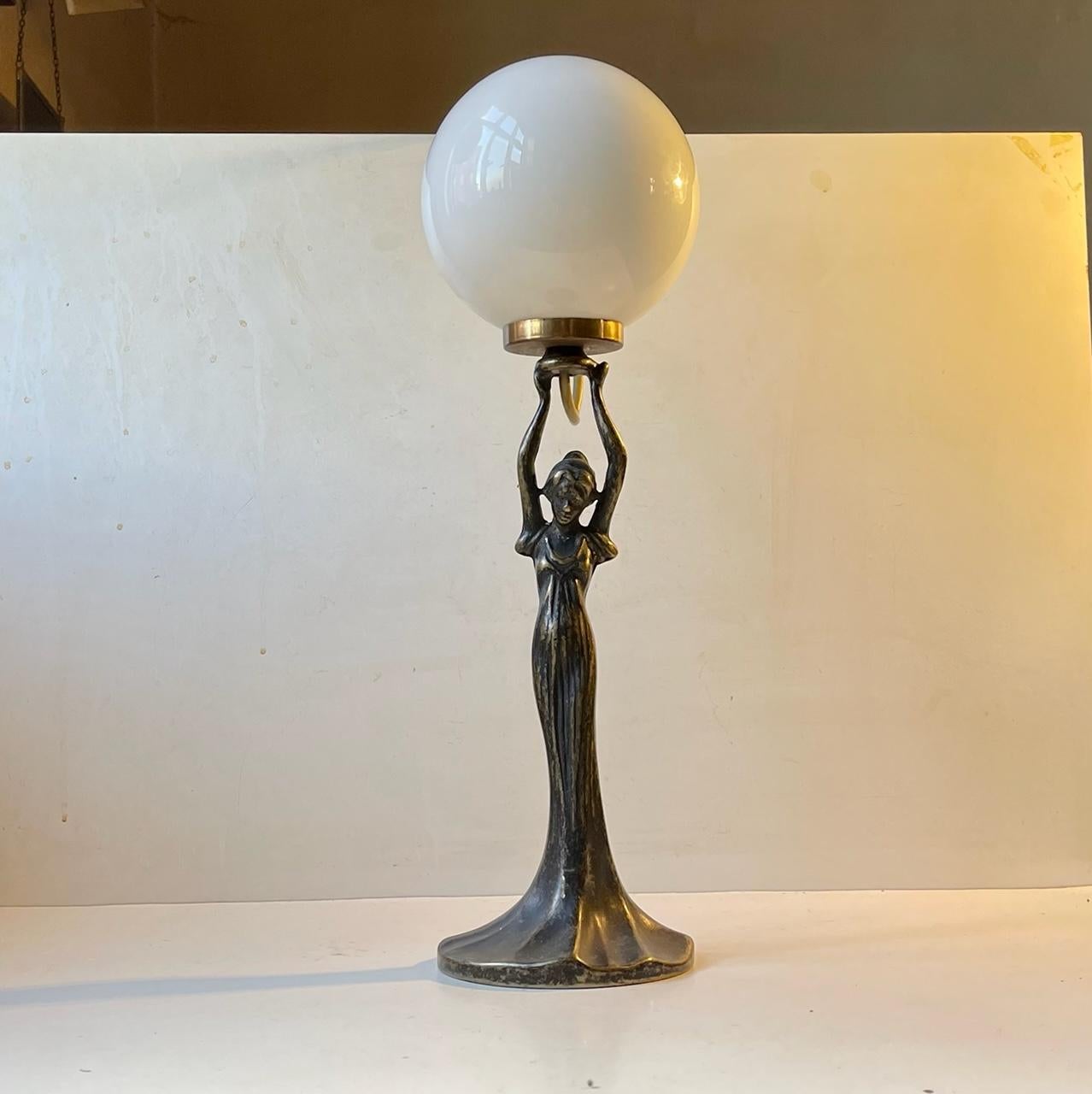 A stylish table lamp in patinated bronze set with a spherical shade in white opaline glass. It was made in Italy during the 1980s closely 'micmic'ing' the style of the 1920s/1930s Art Deco movement. Its imprinted to its base: Made in Italy.