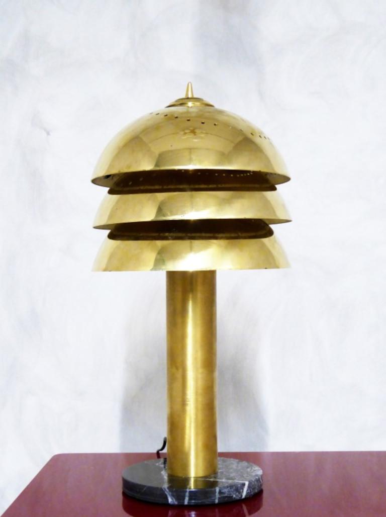 Italian art deco style table lamp with three tiers of perforated brass shades and lamp body in unlacquered natural brass finish, mounted on marble base / Made in Italy
Height: 23.5 inches / diameter: 10.5 inches
LED light
Order only / This item