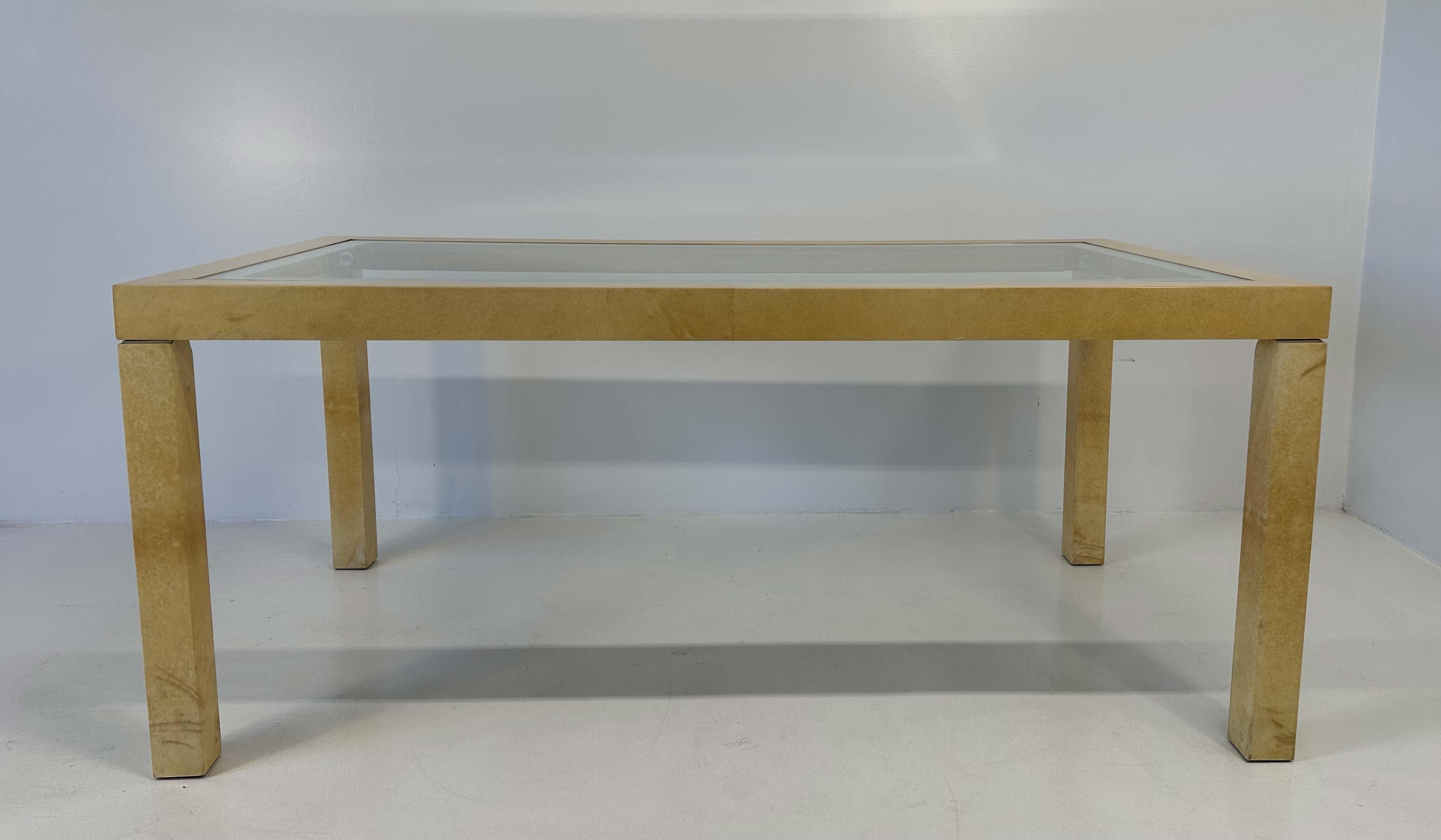 Il tavolo degli anni '70 attribuito ad Aldo Tura è un elegante pezzo di design che incarna la raffinatezza e l'innovazione estetica di quegli anni. Completamente rivestito in pergamena, un materiale prezioso dall'aspetto caratteristico, che