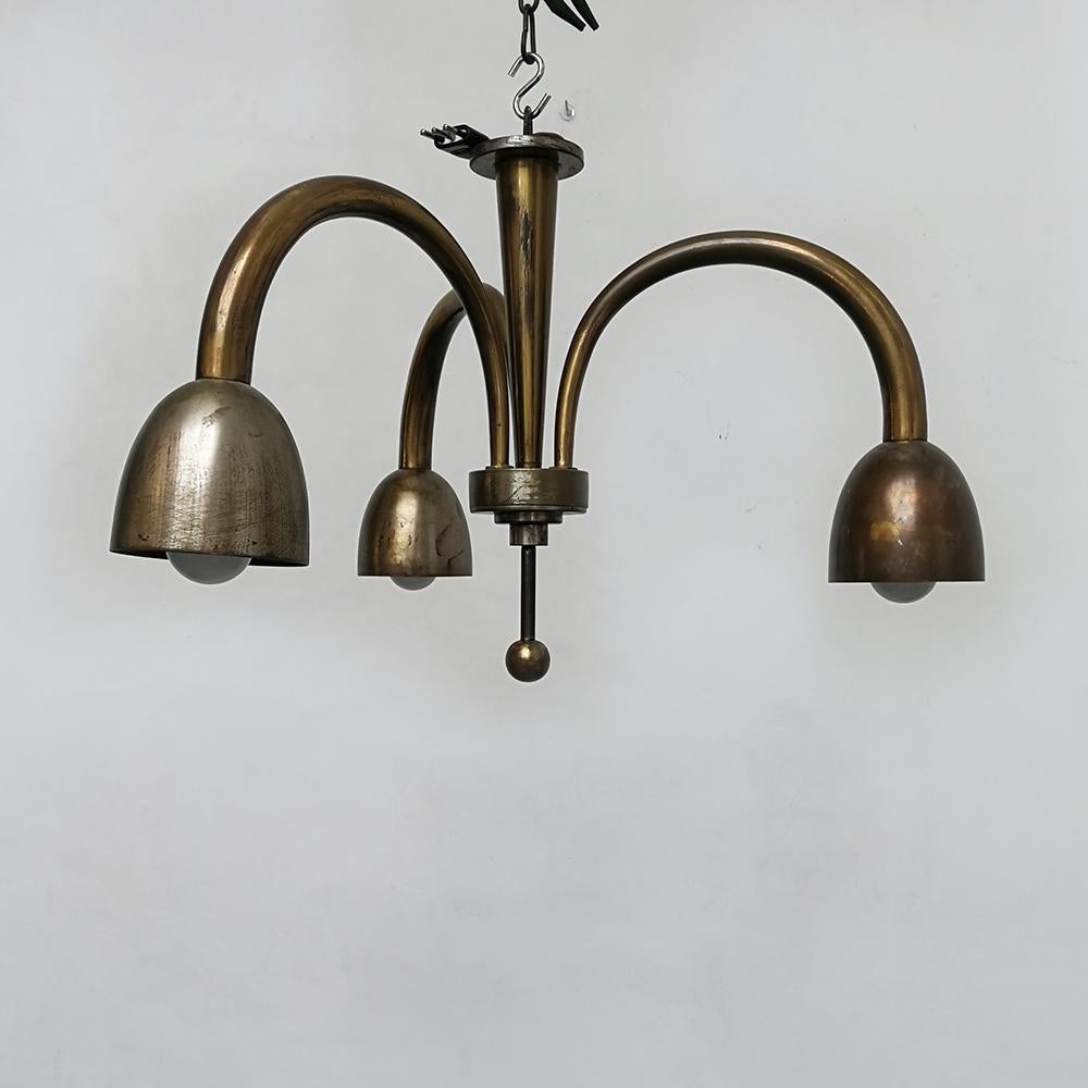 Metal three-light Art Deco ceiling lamp, 1930s
Elegant metal three-light Art Deco chandelier, dating to the 1930s. Structure in golden burnished metal, with three curved brackets that sustain the ceramic lampshades, adapt for an E14 light