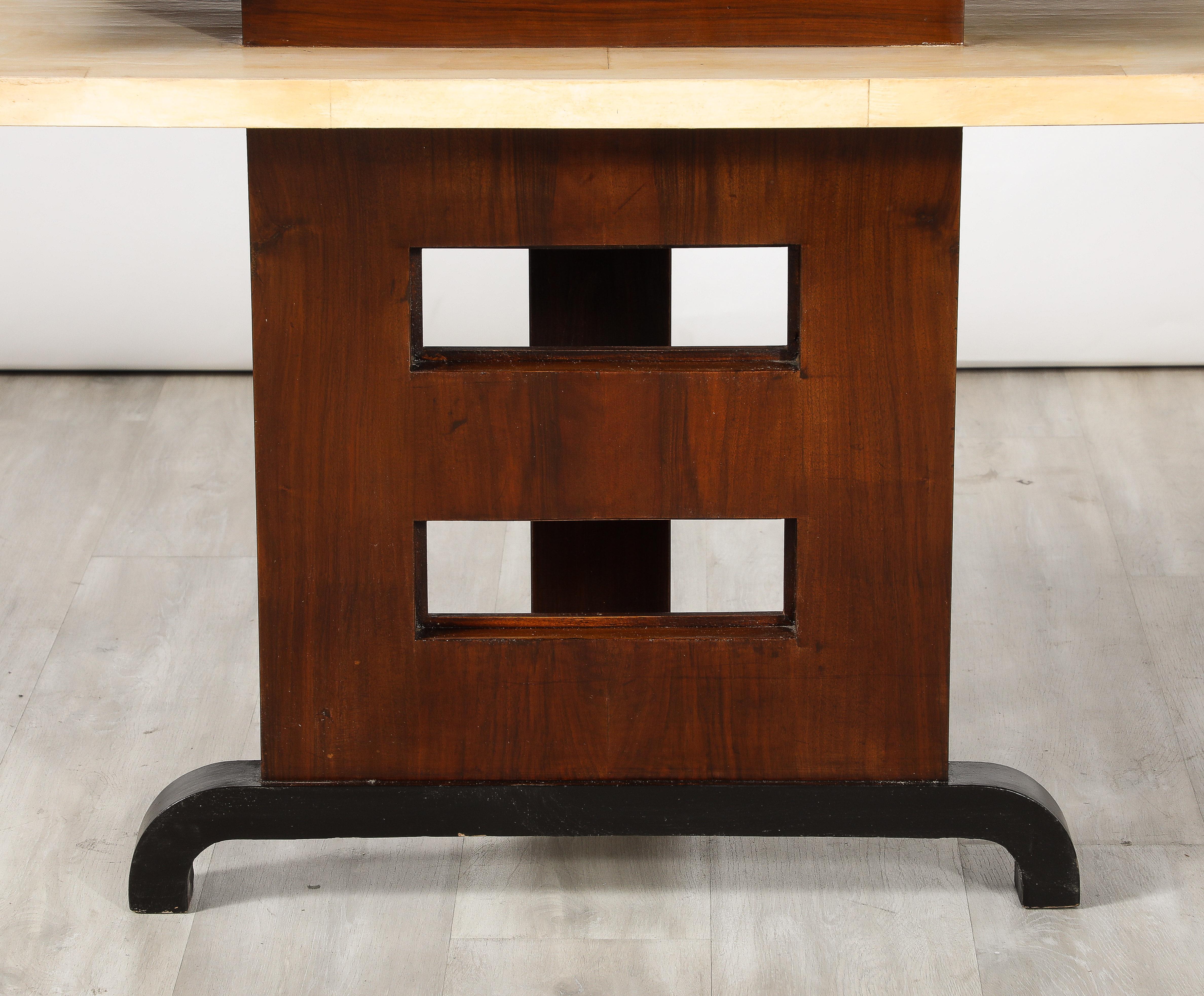 An Italian Art Deco console table with two upper shelves in vellum supported by a rectangular base in palisander wood with square cut-outs.  The central back column and angled base are ebonized.  The use of vellum, palisander and ebonized wood