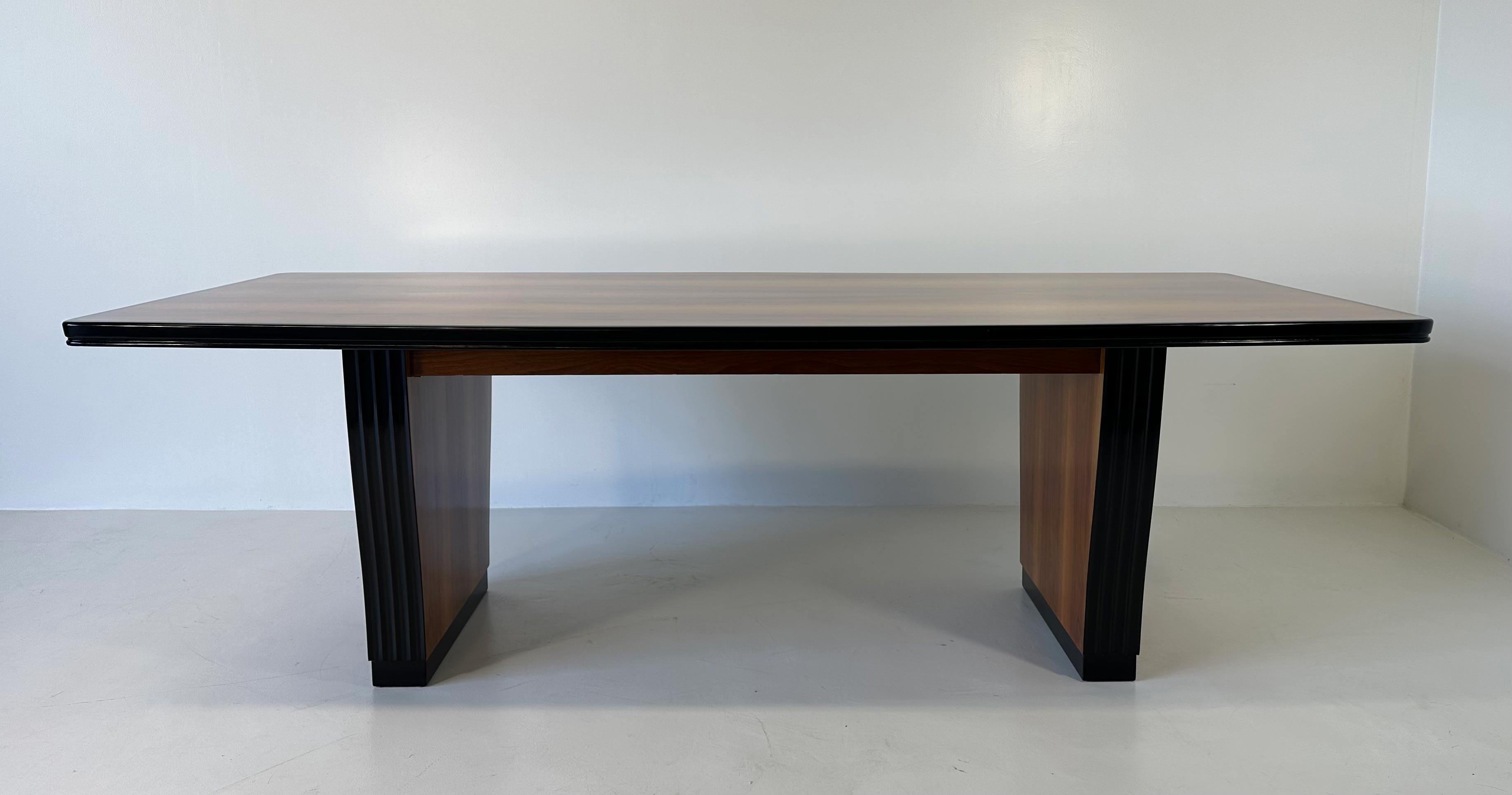 Dieser Art-Déco-Tisch wurde in den 1930er Jahren in Italien hergestellt. 
Es ist komplett aus Nussbaumholz gefertigt und wird von schwarz lackierten Profilen eingerahmt. 
Vollständig restauriert. 