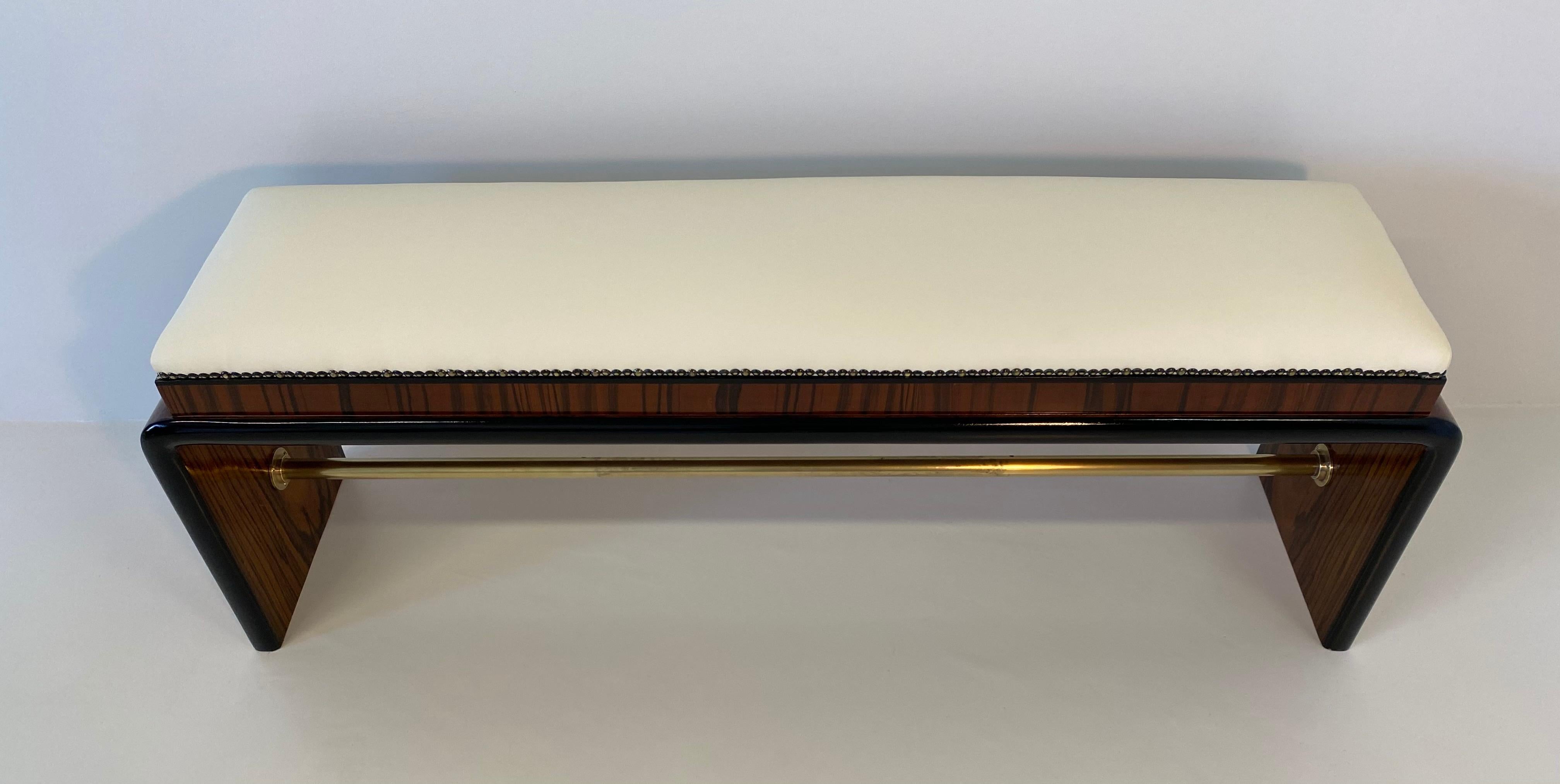 This Art Deco bench was produced in Italy in the 1930s and It is veneered in precious and elegant macassar and walnut briar.
The profiles are in black lacquered wood while the central tube is in brass.
The upholstery and the padding has been