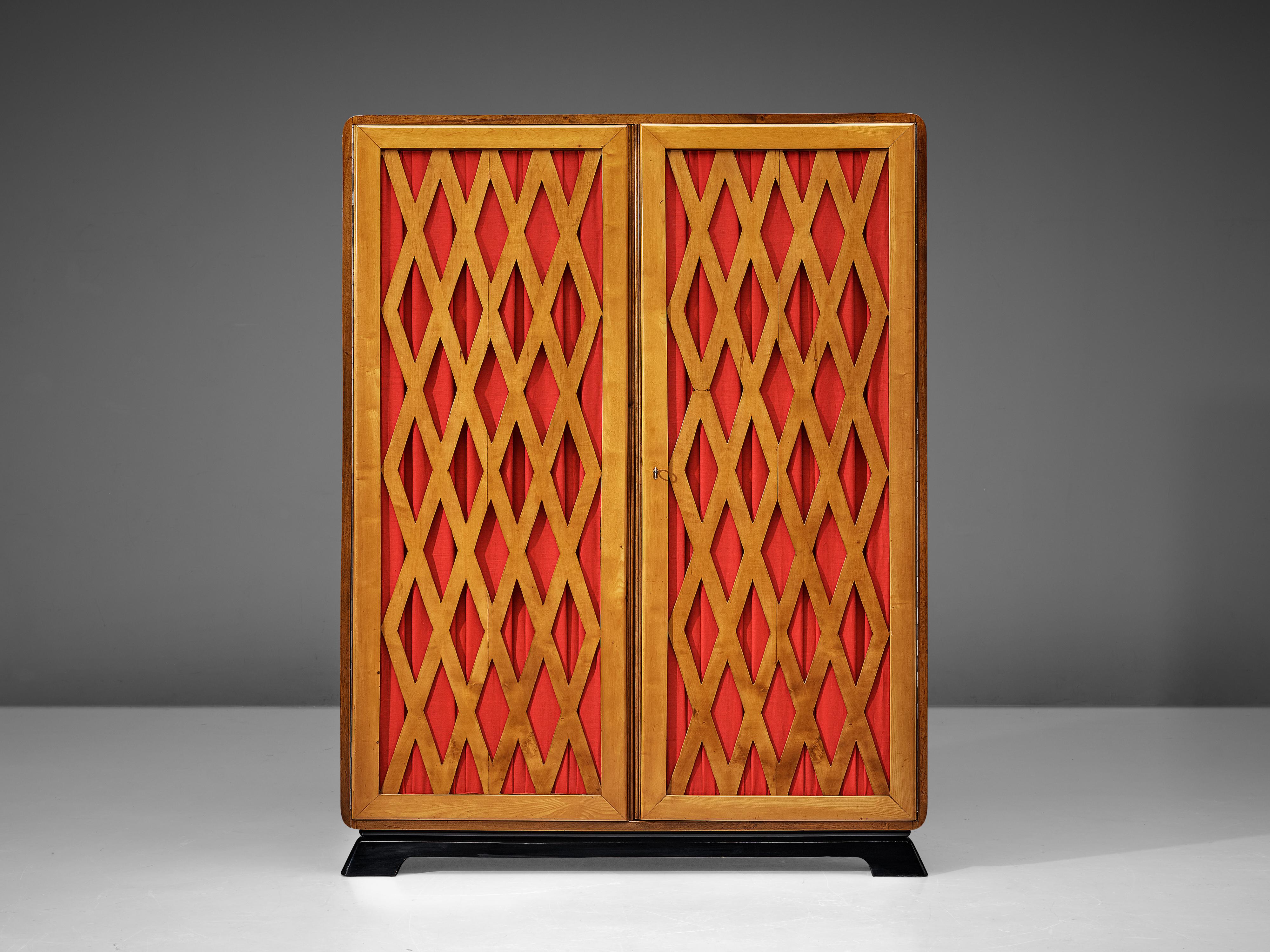 Wardrobe, walnut, fabric, Italy, 1930s. 

An elegant Art Deco wardrobe in walnut that features a checkered lattice frame in the doors. The open structure reveals a bright red fabric which creates a warm appearance in combination with the walnut. The