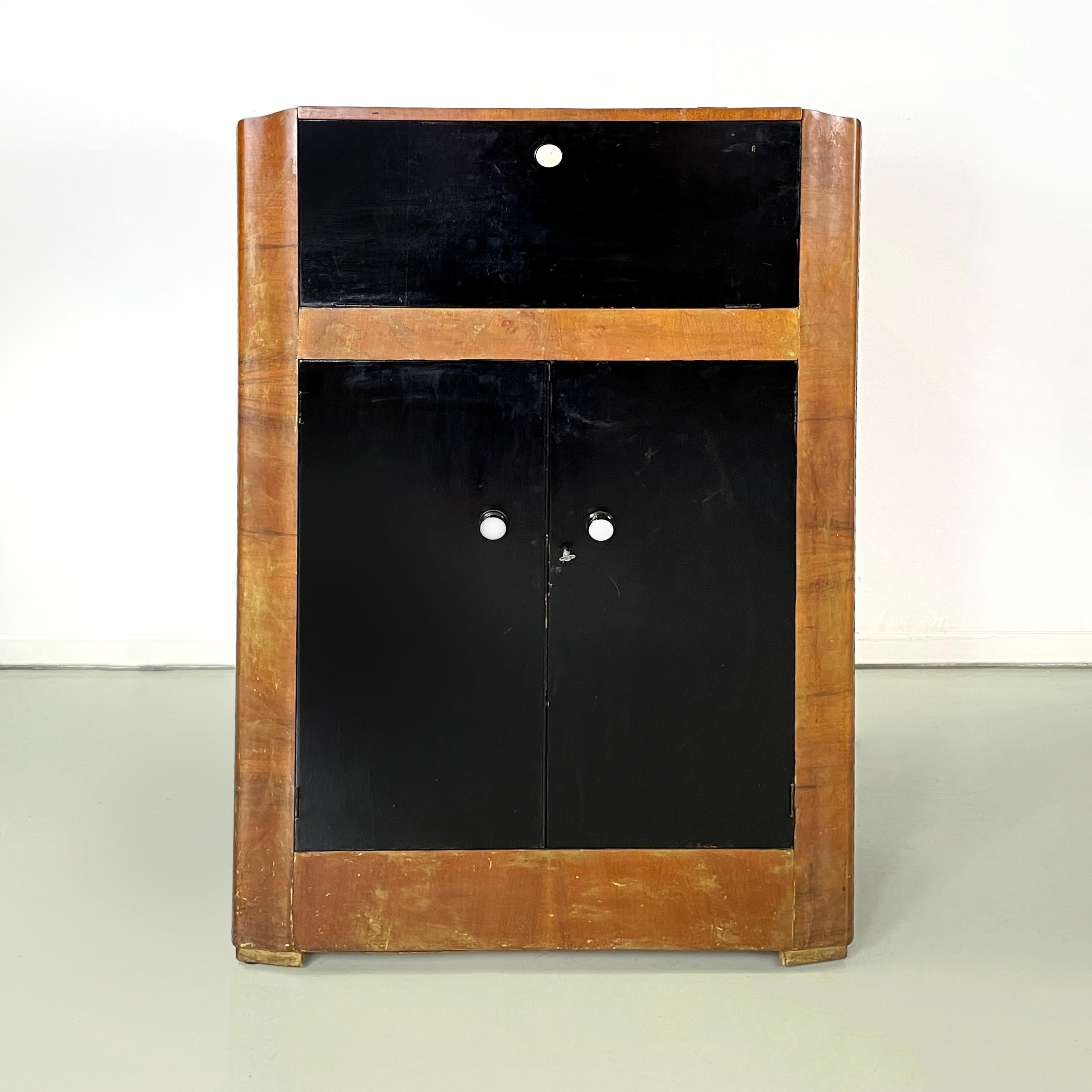 Italian art deco Wooden bar cabinet with lamp and mirrors, 1940s
Bar or cocktail cabinet with two compartments, entirely in natural color wood and black painted wood. The upper compartment has a double flap opening with an internal metal mechanism