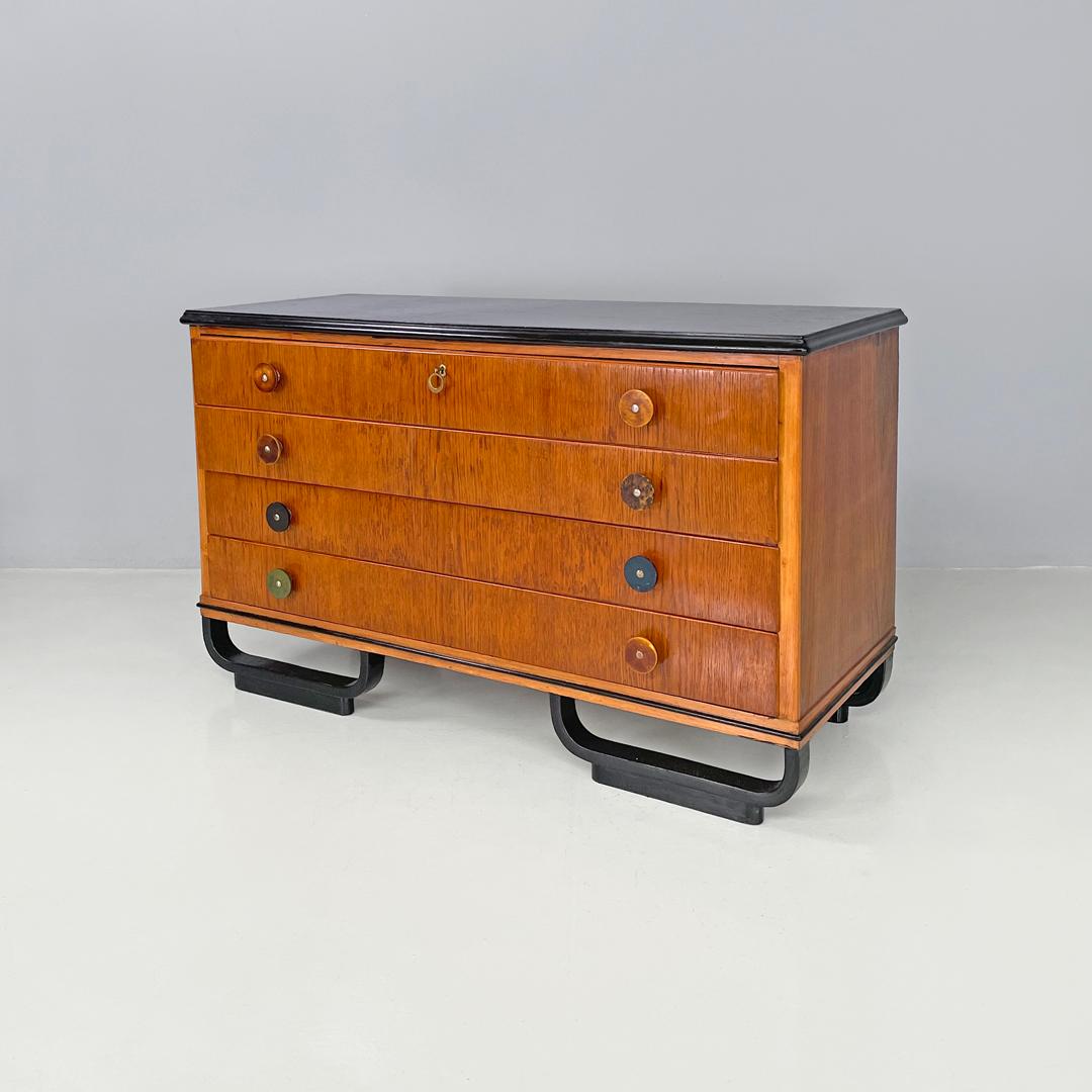 Italian Art Deco wooden chest of drawers with black top and arched feet, 1930s
Chest of drawers with rectangular wooden base. The top is lacquered in black, as are the four arch-shaped feet with rectangular ground support. It has four drawers with