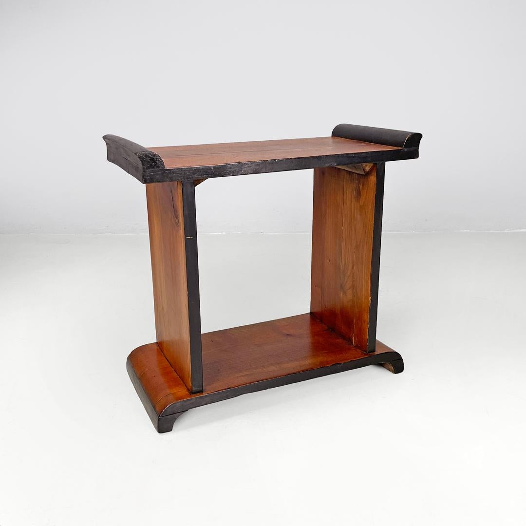 Table basse italienne Art déco en bois avec profils arrondis peints en noir, années 1940
Table basse entièrement en bois avec une base rectangulaire et des profils peints en noir. Sur les côtés du plateau, il y a deux bandes décoratives incurvées,