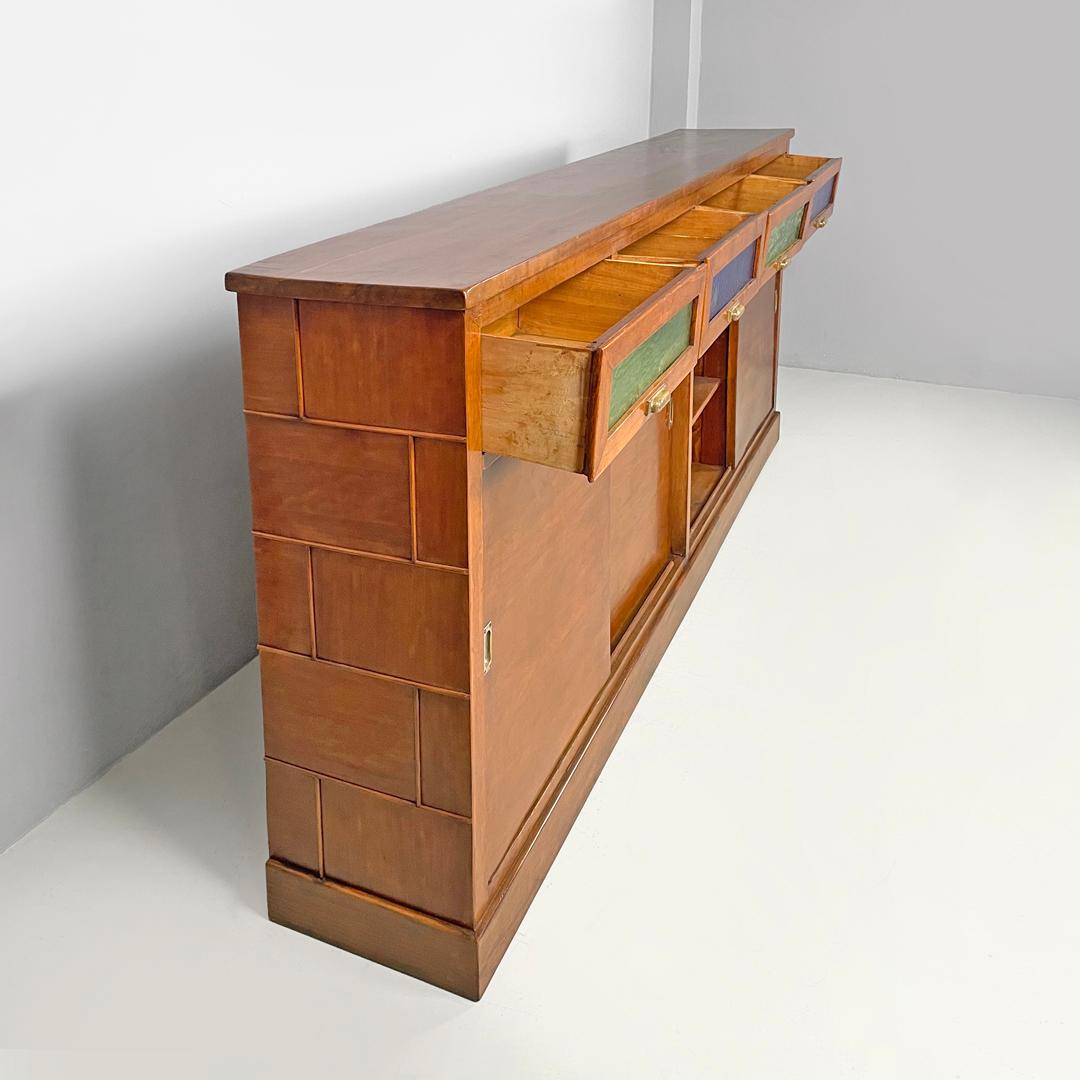 Credenza italiana Art Deco in legno con vetri colorati verdi e blu, anni '30
Credenza o armadio in legno. Sotto il piano ci sono quattro cassetti con frontali in vetro cattedrale verde e blu e maniglie in ottone. Sotto ci sono due scomparti con