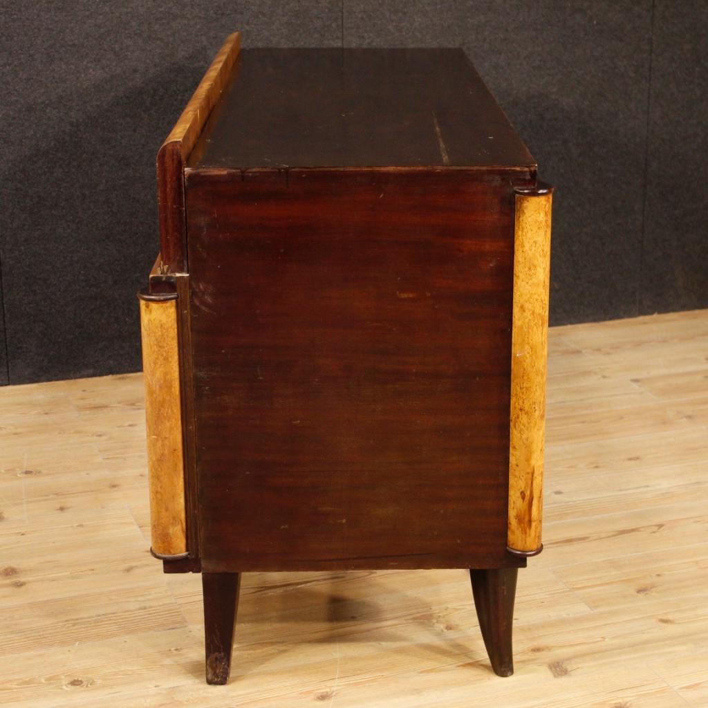 Italian writing desk from the mid-20th century. Furniture of particular shape and construction, finished from the center and carved in woods of mahogany, briar of tuja, beech and fruit woods. Desk with three front drawers with wooden top in an