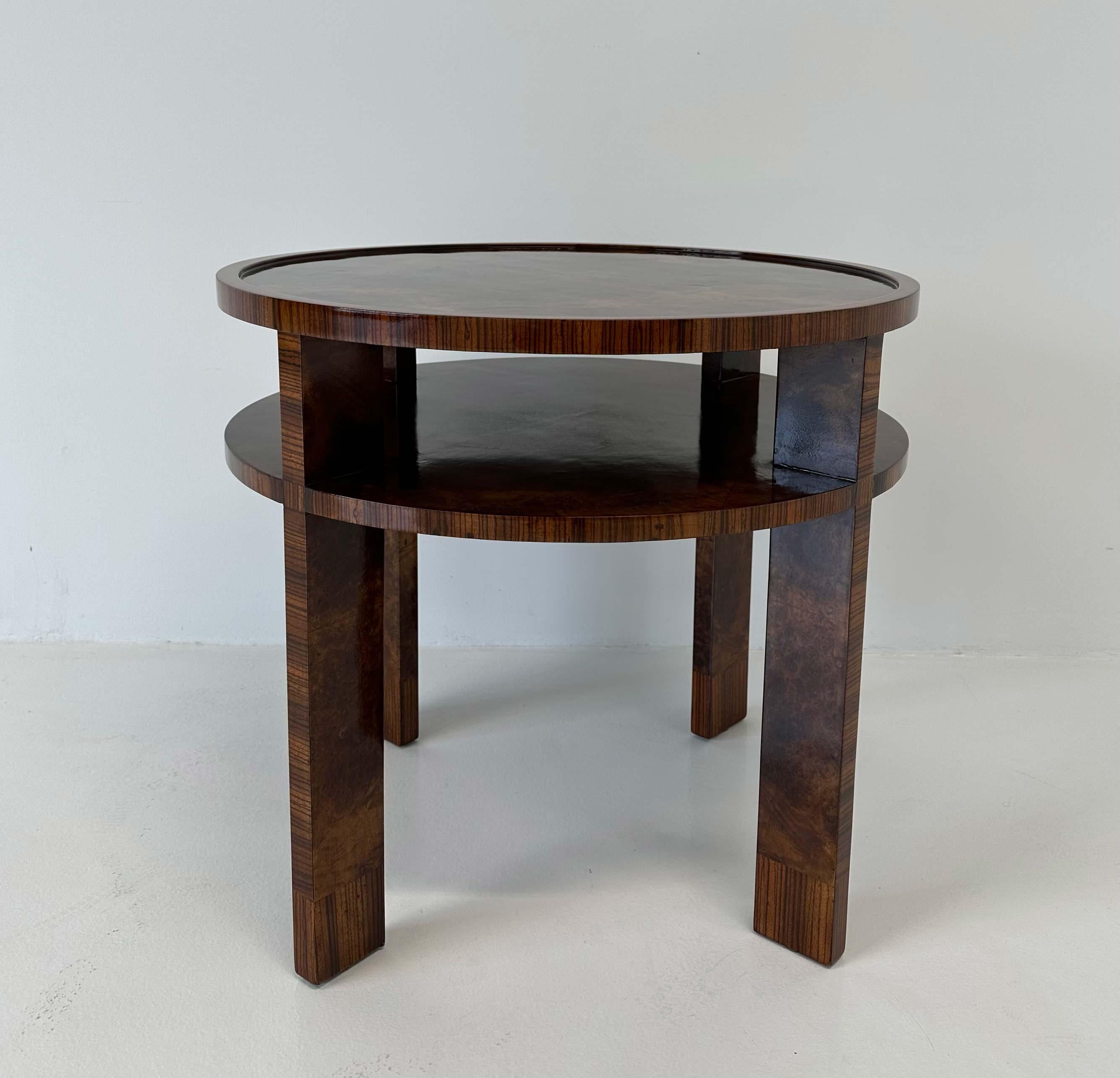 Questo tavolino da caffè in stile Art Déco è stato prodotto in Italia negli anni Trenta. I piani e le gambe sono in legno di noce, mentre i profili e i dettagli sono in legno di zebra. 
Completamente restaurato. 