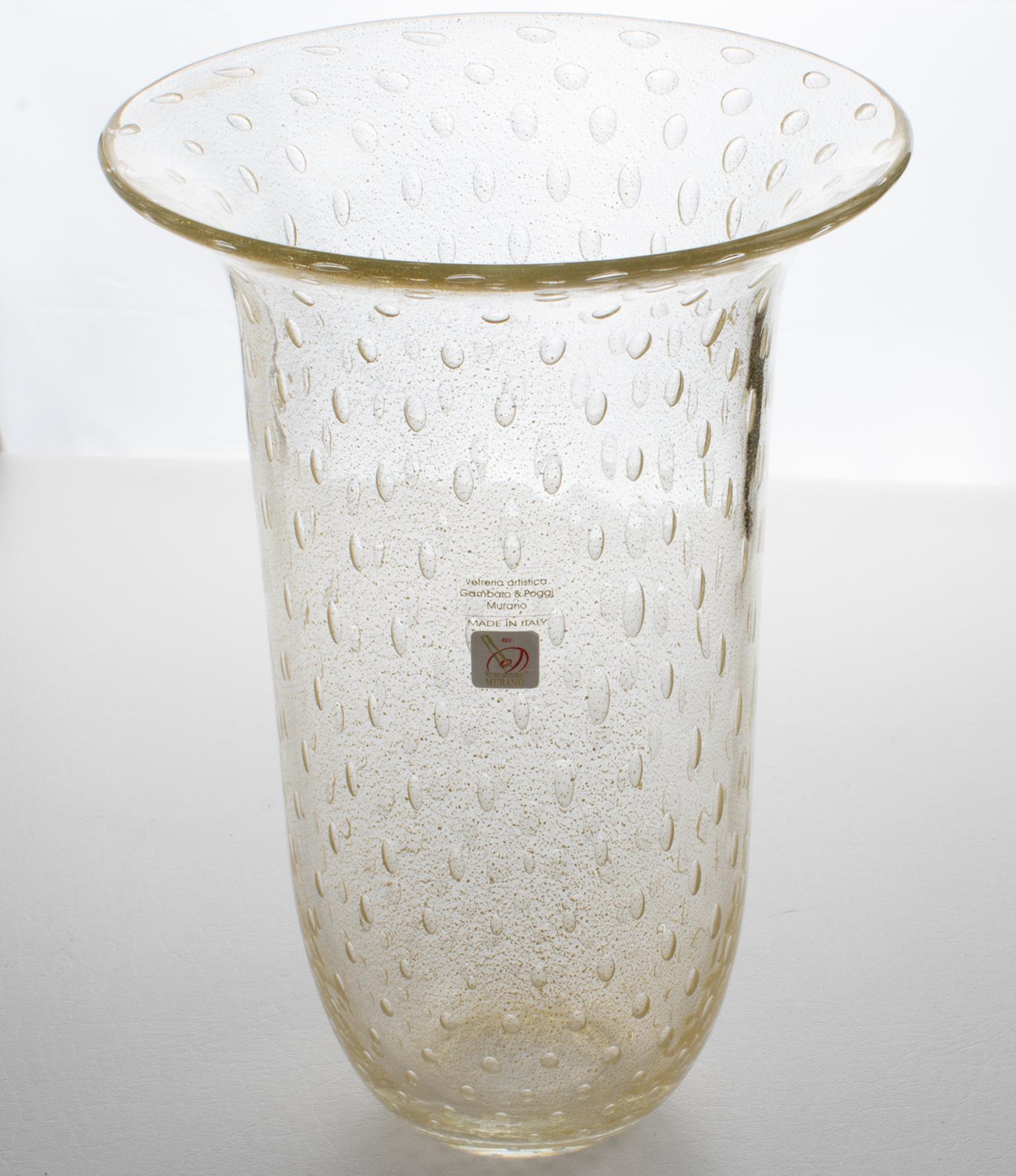 Gambaro & Poggi, de Murano, fabricaron artesanalmente este precioso jarrón de vidrio soplado de Arte Italiano. La forma de tulipán alto y escultural tiene inclusiones de escamas de oro infundidas y la técnica de la 