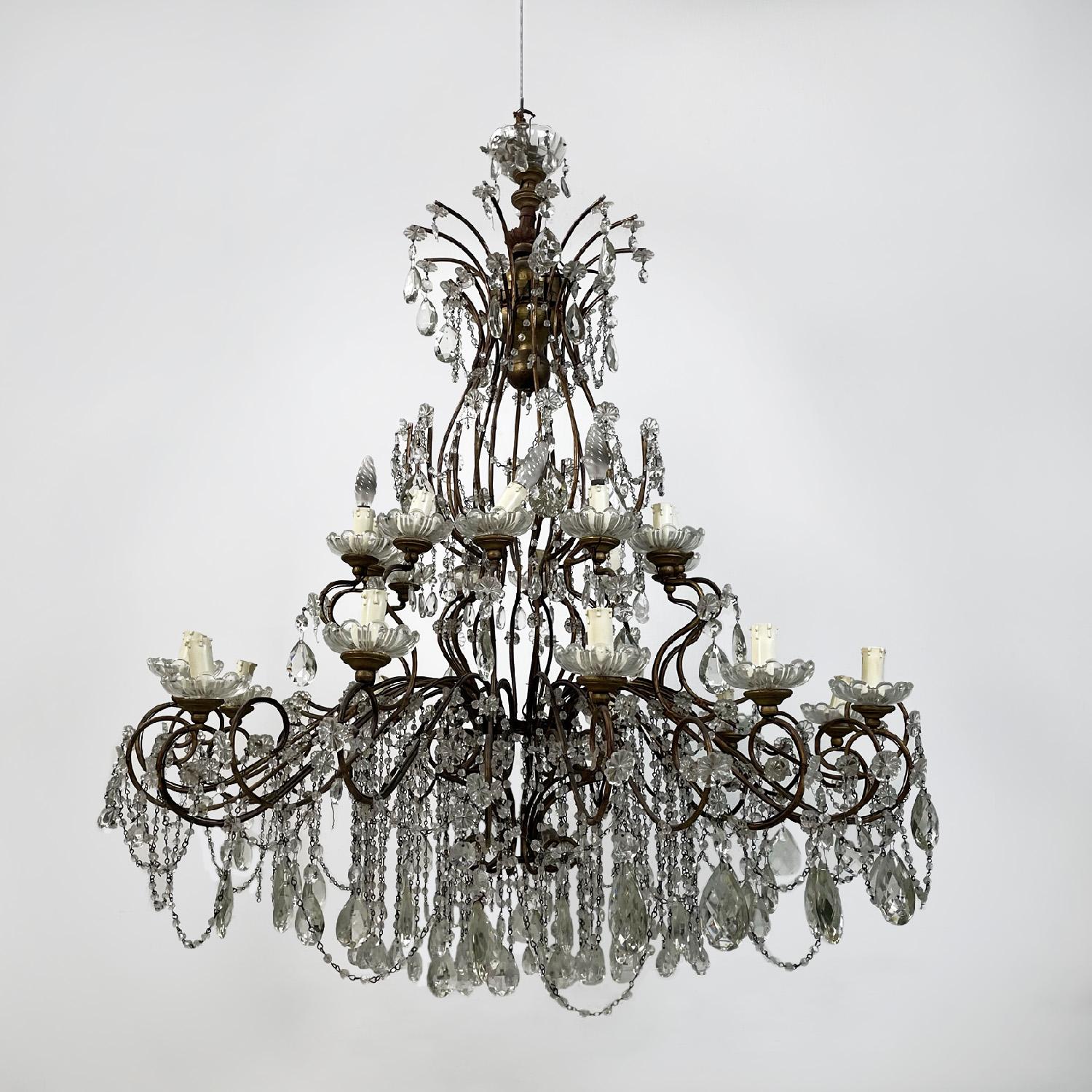 Italian antique crystal drops golden wrought iron and wood chandelier, 1900s
Large chandelier with round structure in gilded wrought iron, wood and crystal drops. It has two rows of arms: the lower one is made up of 24 arms that extend to become the